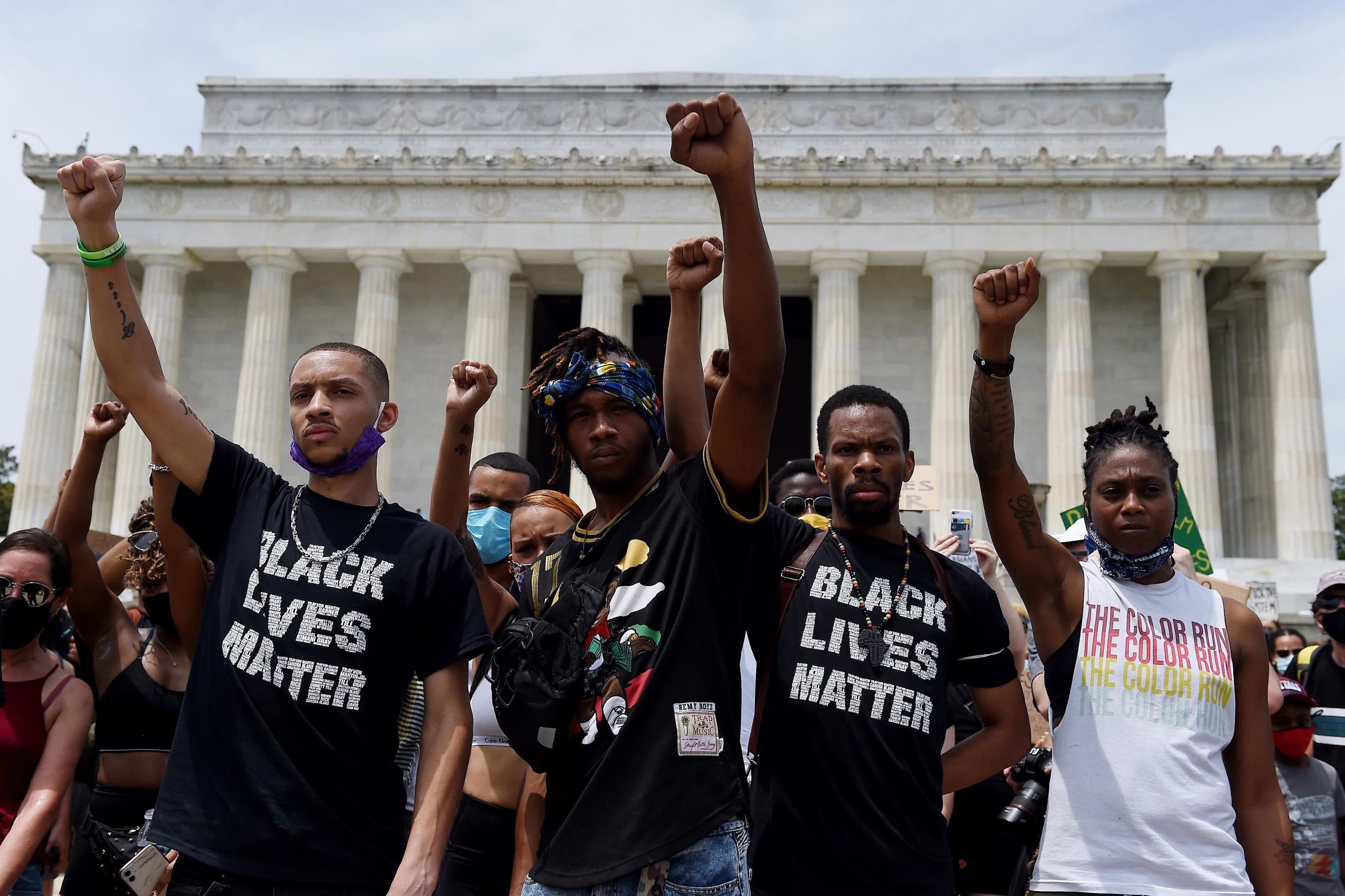 Demonstrator raise their fists at the Lincoln Memorial during a protest on June 6 in Washington, DC