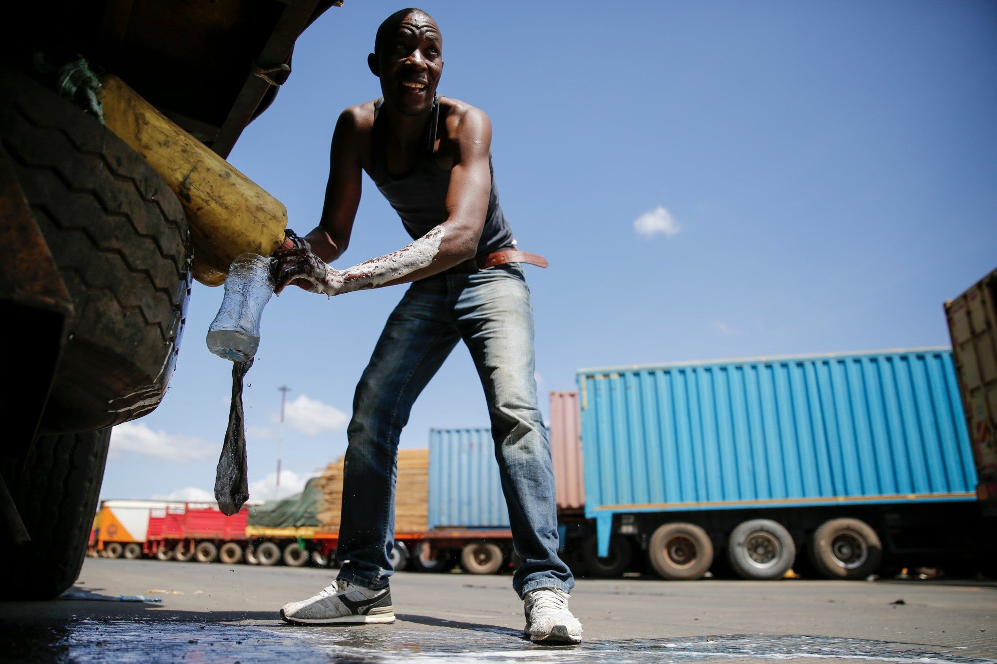 Tanzanian truck driver Ally Akida Samwel washes his hands next to his truck as he waits to be allowed to entry to Kenya