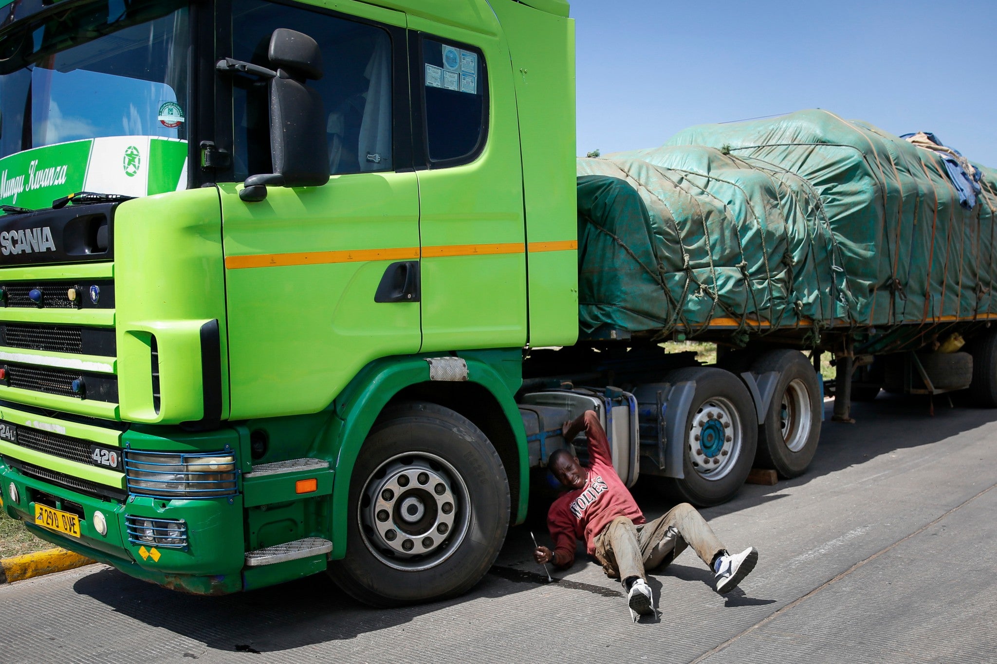 Tanzanian truck driver Ally Akida Samwel fixes the brakes of his truck