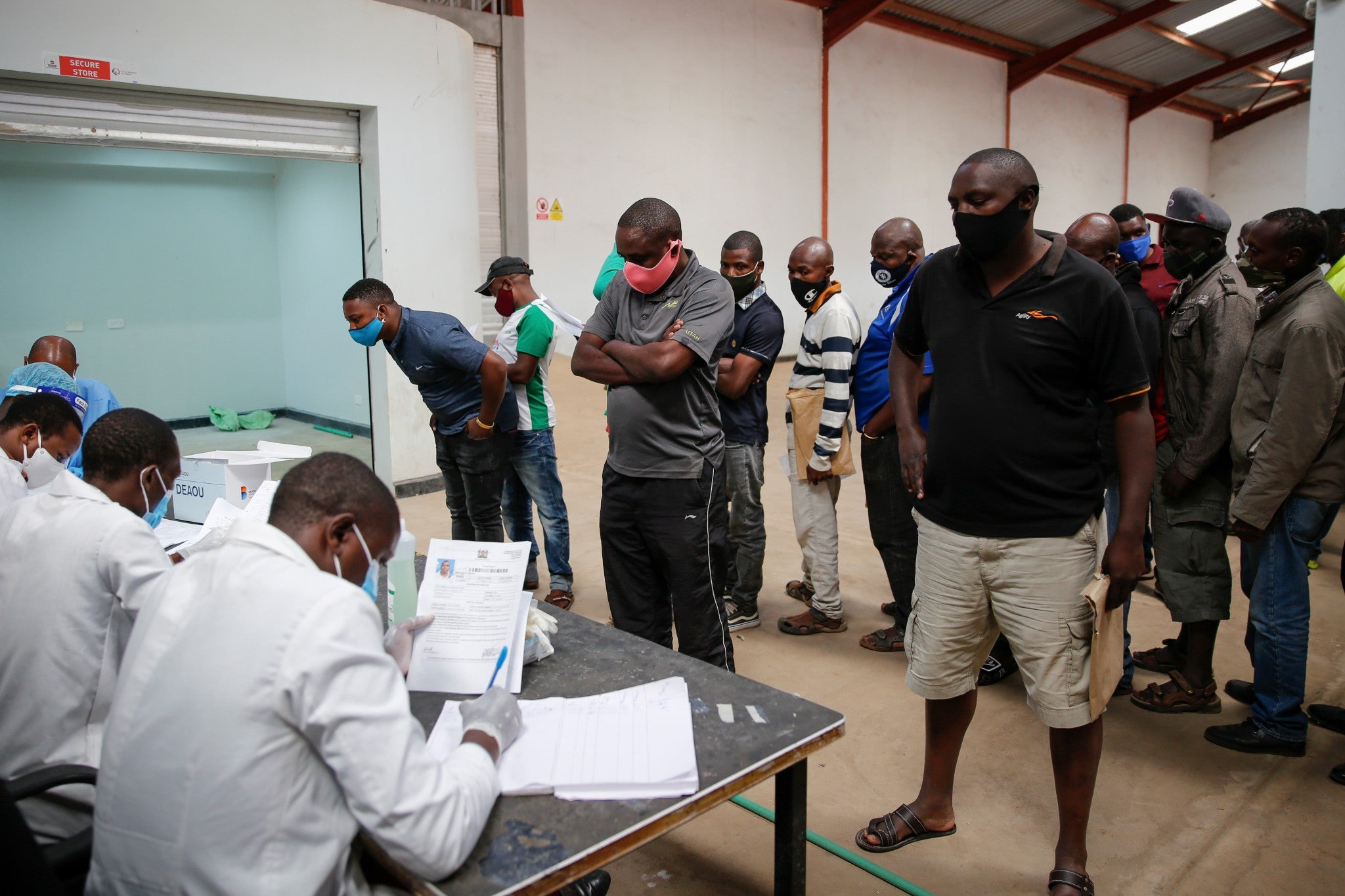 Truck drivers entering Kenya queue to be tested for the coronavirus