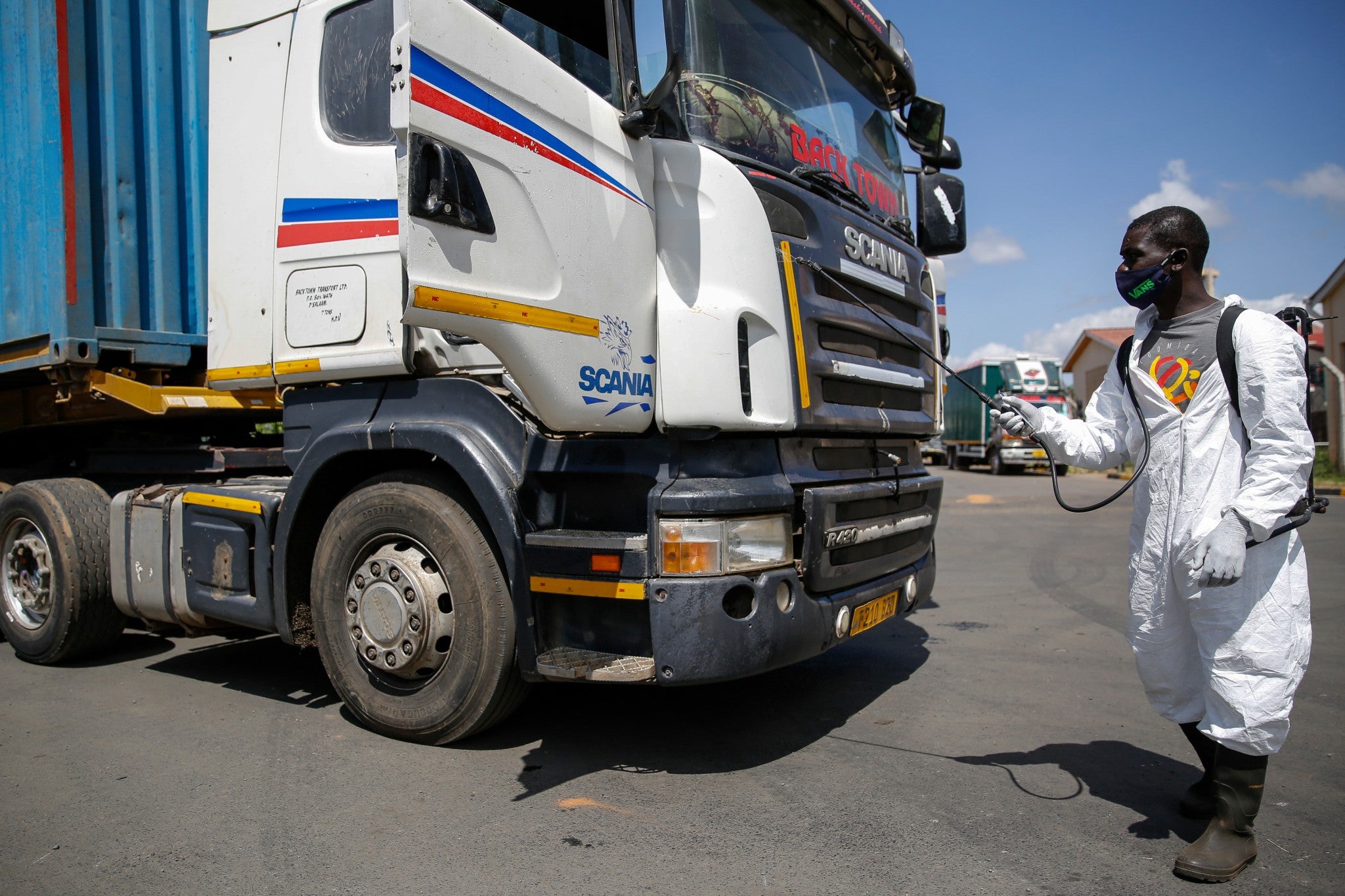 A health worker sprays disinfectant on trucks