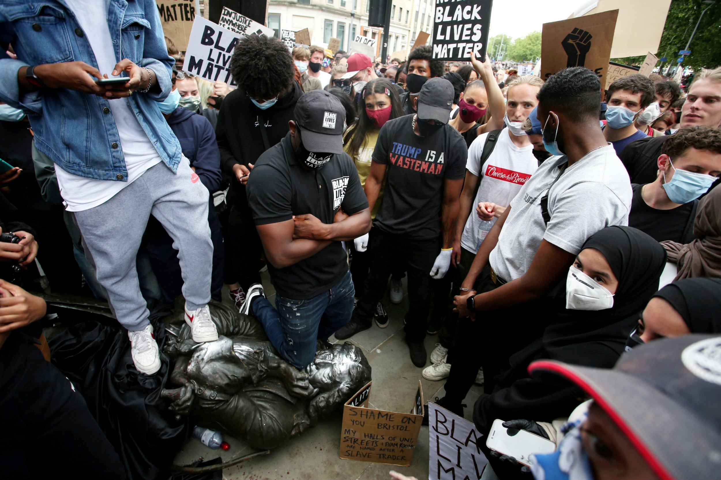 A protester presses his knee into the neck of the Edward Colston statue