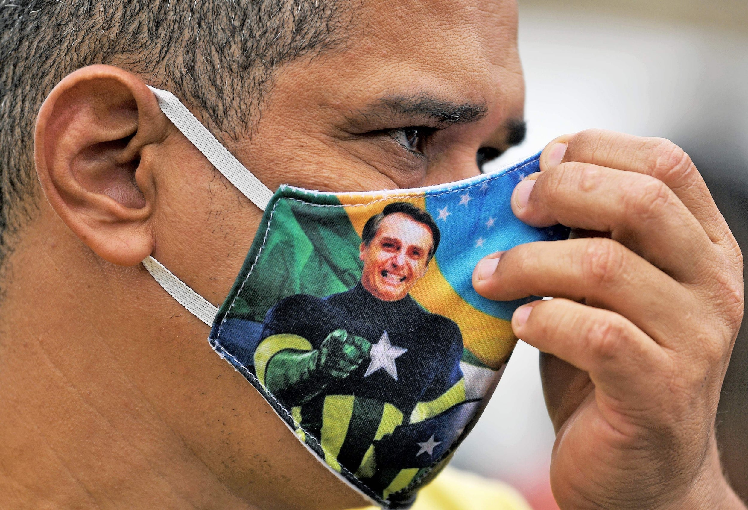 A Bolsonaro supporter wears a face mask with the president's image during a demonstration in Rio de Janeiro
