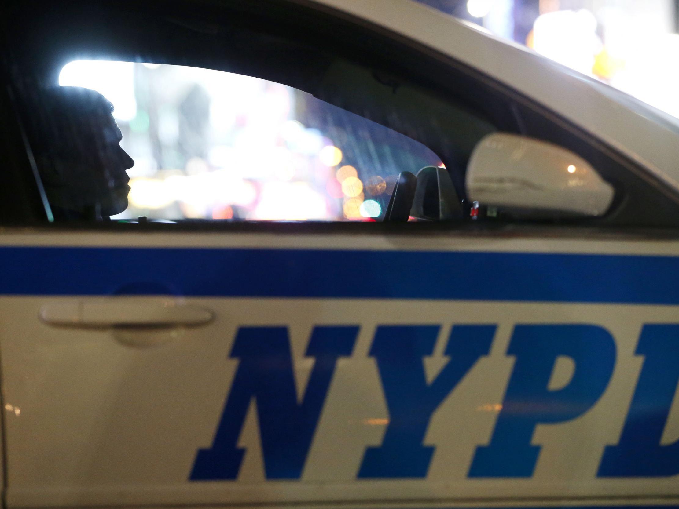 A New York City police officer sits in a cruiser at a checkpoint surrounding Times Square