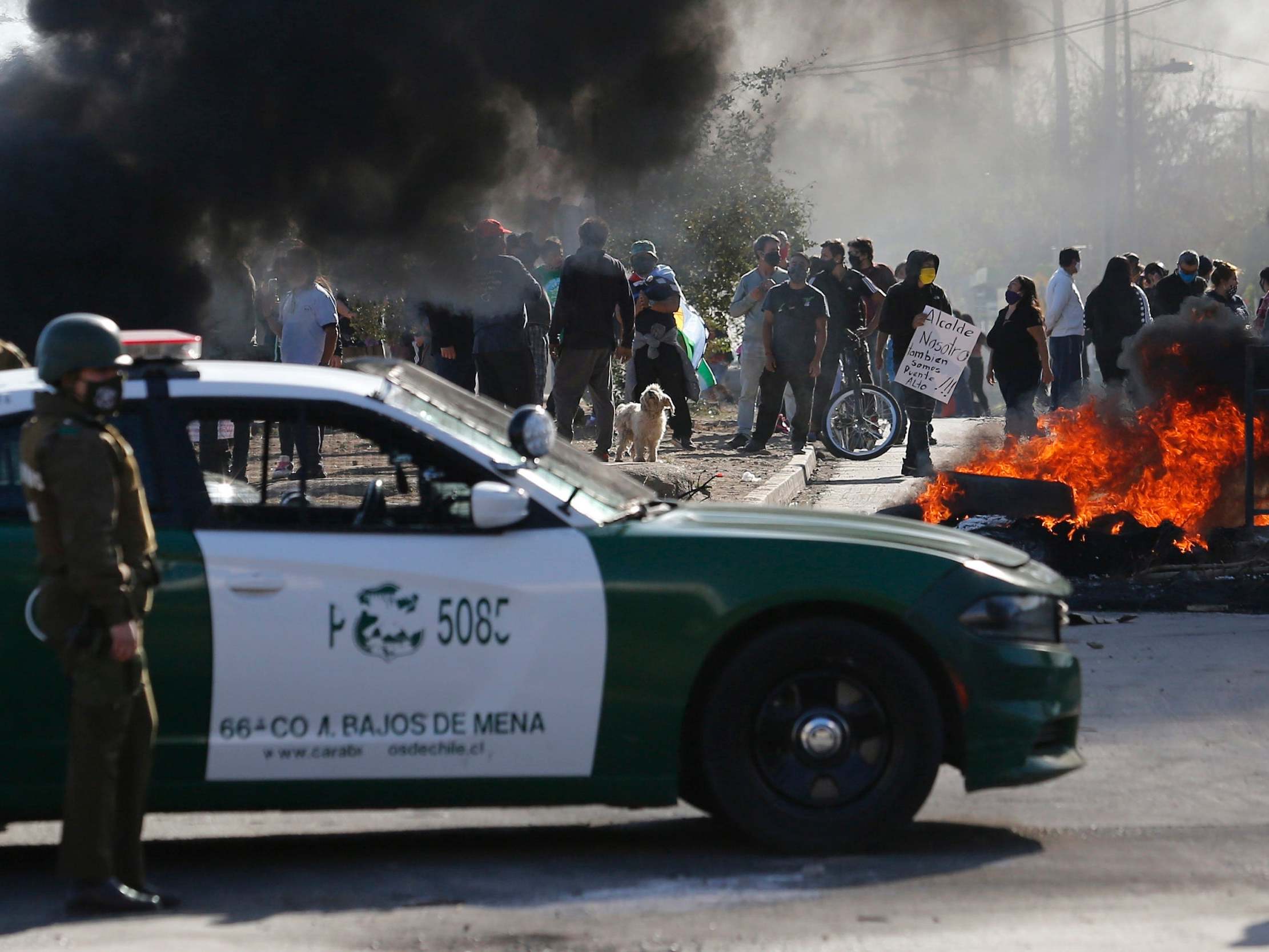 Chilean riot police stand guard during a protest to demand government aid during the Covid-19 pandemic