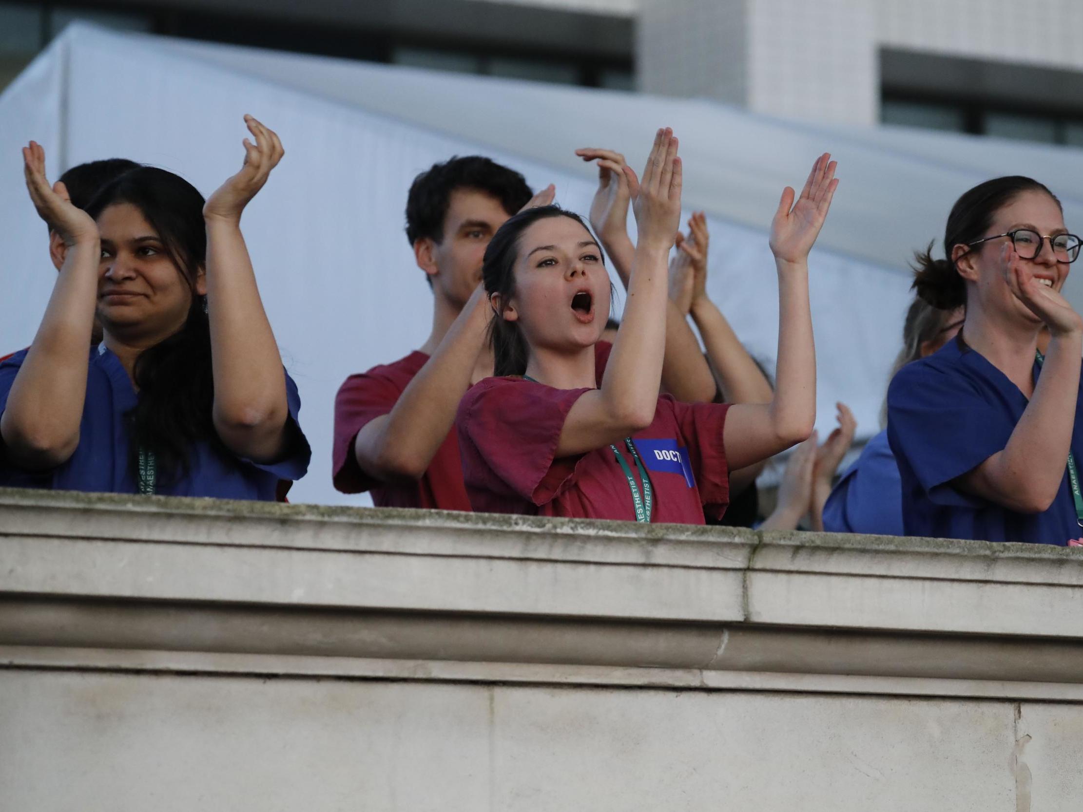 NHS staff take part in Clap for Carers on the banks of the Thames near St Thomas' Hospital in London, 23 April 2020