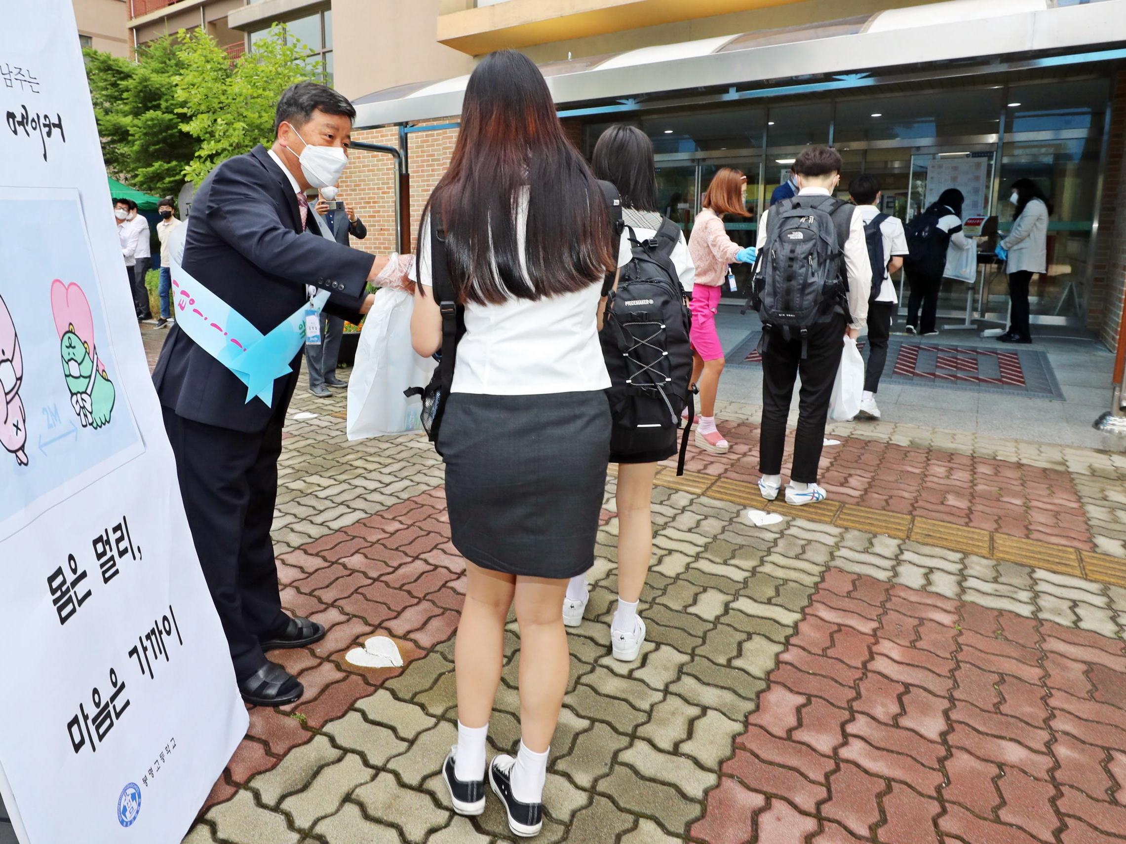 Students arrive at school while keeping distance from each other at Bongmyeong High School in Cheongju, South Korea