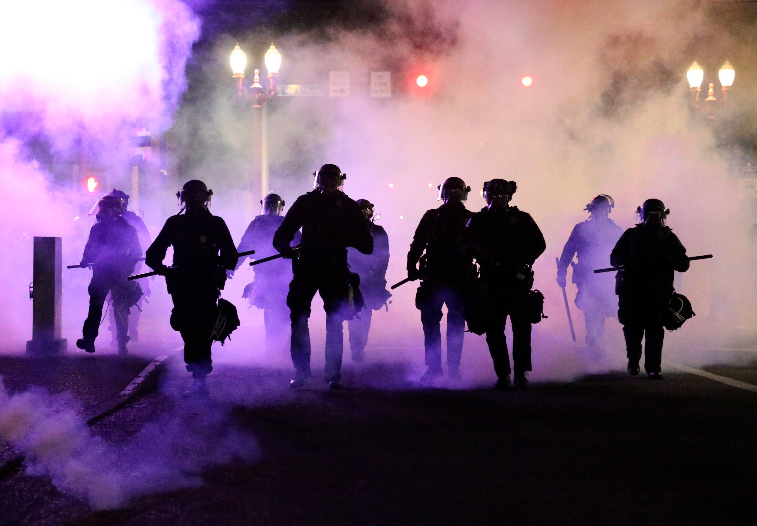 Police officers in Portland march towards protesters after firing teargas