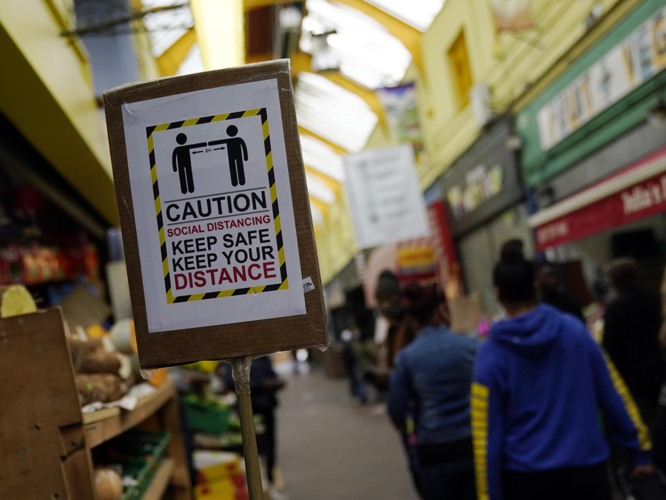 A sign encouraging social distancing in Brixton Market, London