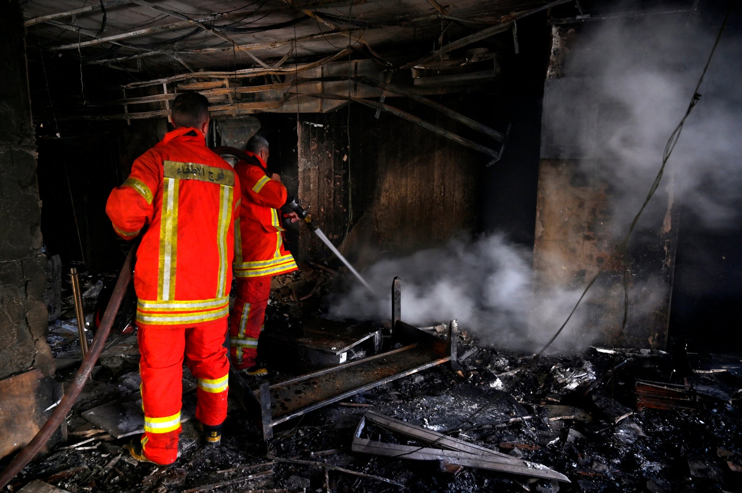 The Beirut fire brigade extinguishes a smouldering bank after it was set on fire overnight