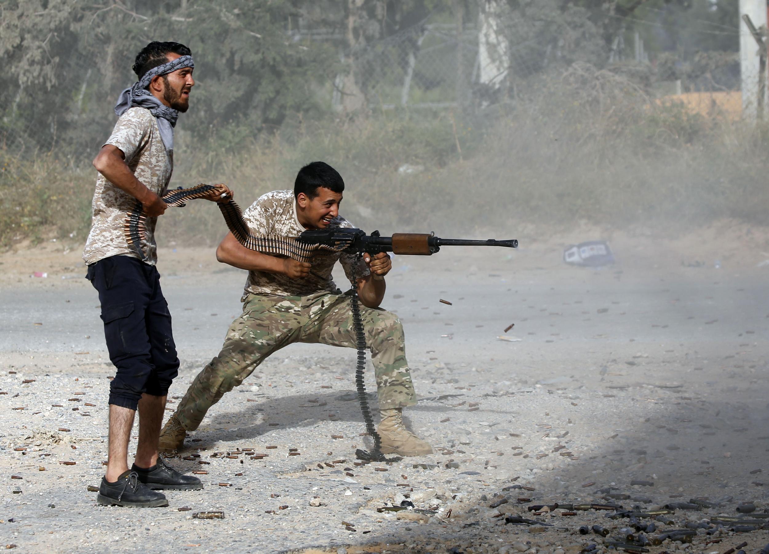 A fighter loyal to the Government of National Accord (GNA) fires his rifle during clashes with strongman Khalifa Haftar south of Tripoli, Libya