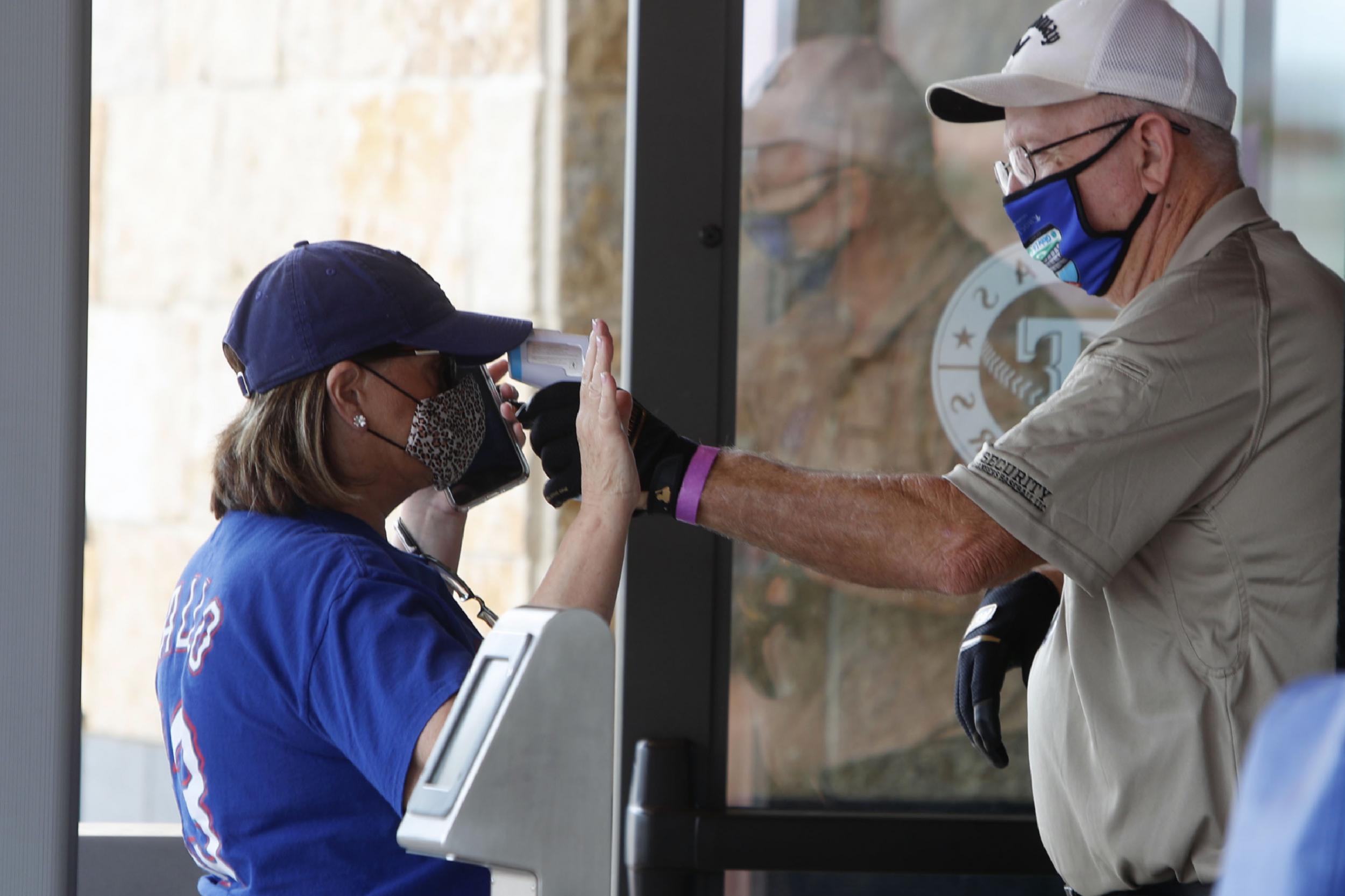 Amid concerns of the spread of the virus that causes COVID-19, a baseball fan has their temperature checked by a security guard before being allowed to tour Globe Life Field, home of the Texas Rangers baseball team in Arlington, Texas, Monday, June 1, 2020. (AP / LM Otero )