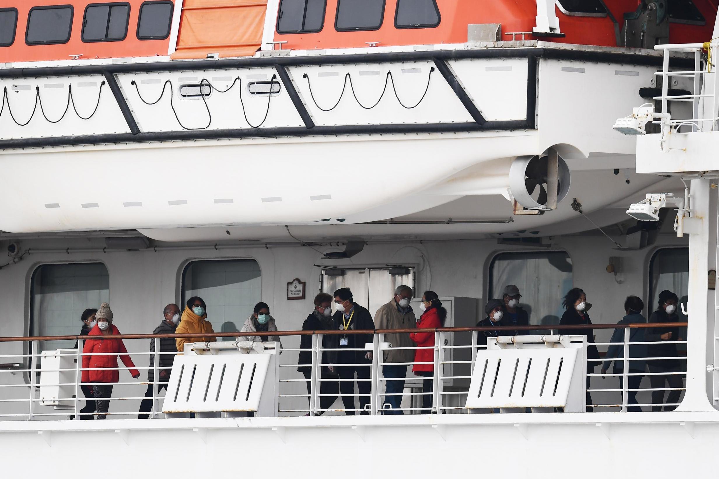 Passengers walk along the deck of the Diamond Princess cruise ship in February 2020. Around 3,600 people were quarantined onboard due to fears of a coronavirus outbreak