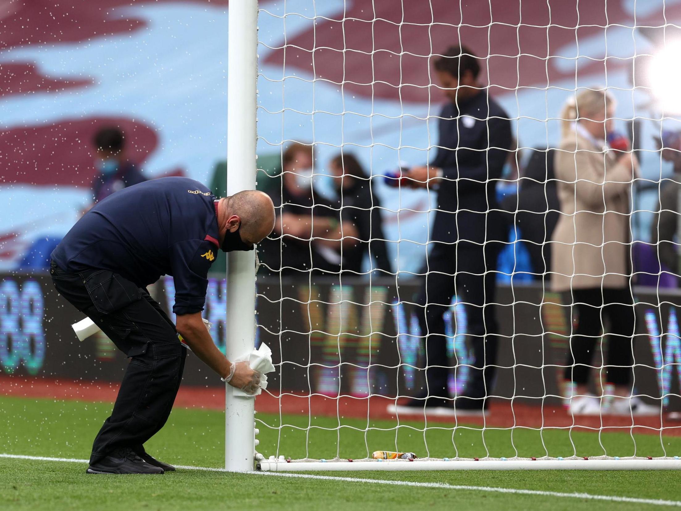 A member of staff cleans the goalposts at Villa Park ahead of kick-off