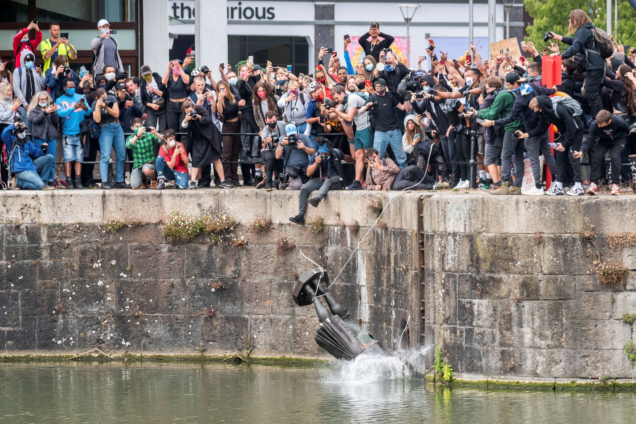 The statue of 17th-century slave trader Edward Colston is thrown into the harbour