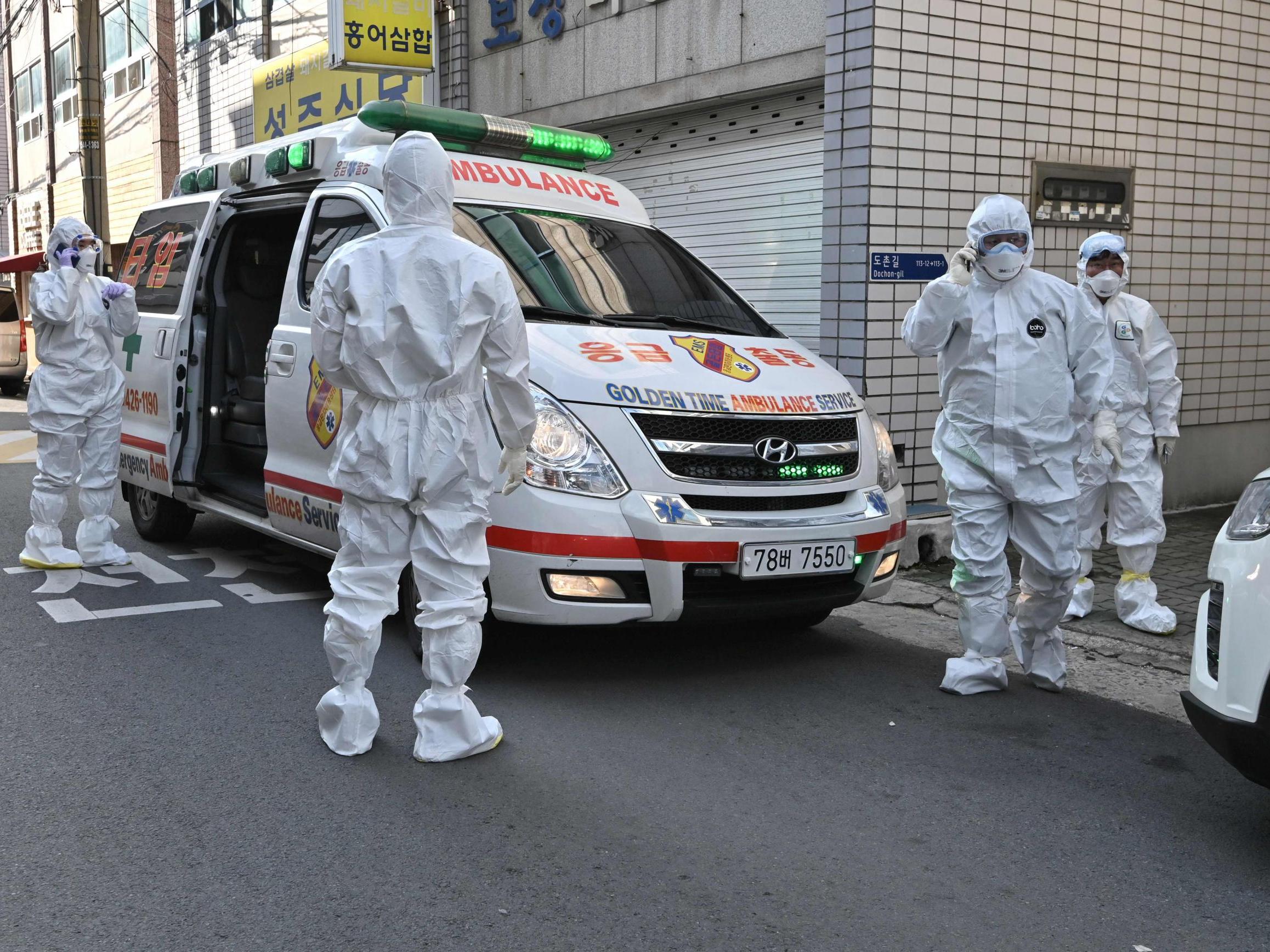 Medical workers visit a residence of people with suspected symptoms of Covid-19 to take samples, near the Daegu branch of the Shincheonji Church of Jesus