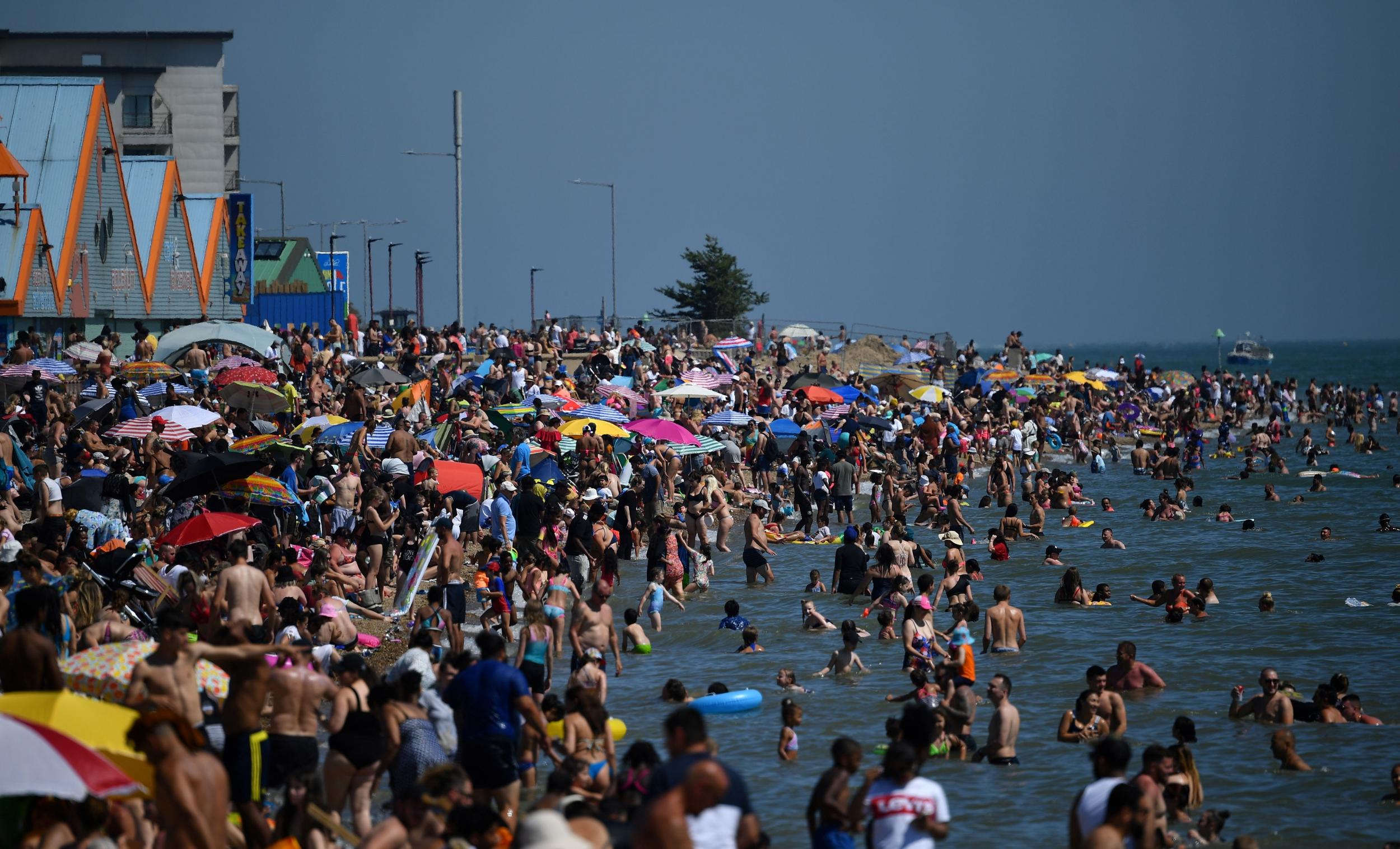 Beachgoers enjoy the sunshine as they sunbathe on the beach and play in the sea in Southend on Sea, southeast England, on 24 June