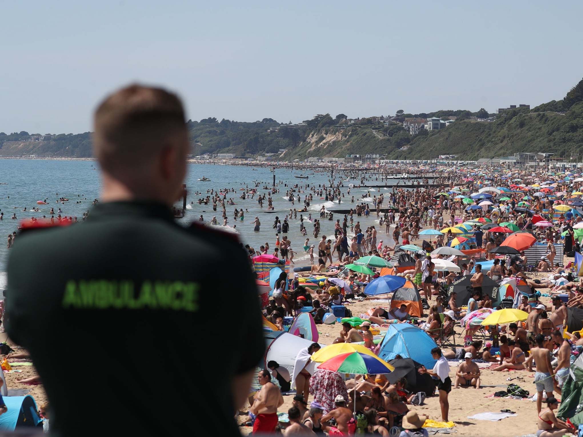 An ambulance worker looks out from Bournemouth Pier as large crowds gather on the beach on Thursday (Andrew Matthews/PA)