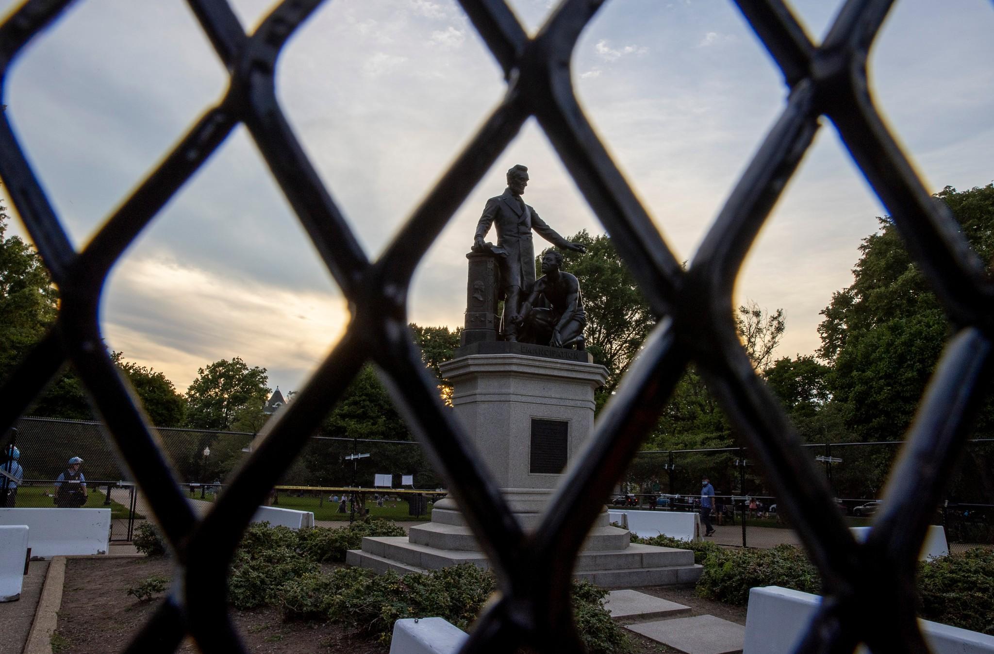 Protesters for and against the removal of the Emancipation Memorial debate in Lincoln Park