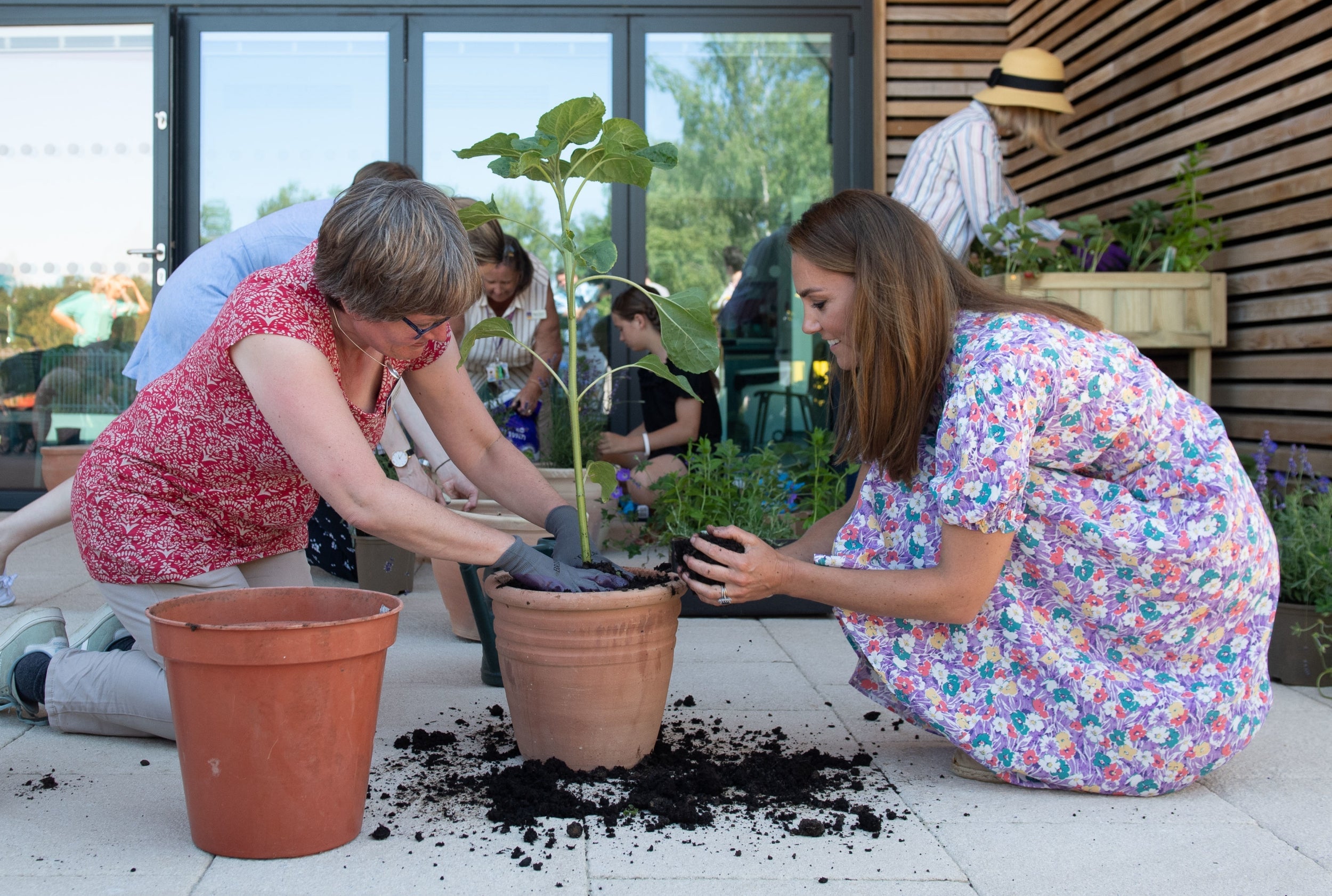 The Duchess of Cambridge helps to pot plants and herbs during a visit to The Nook