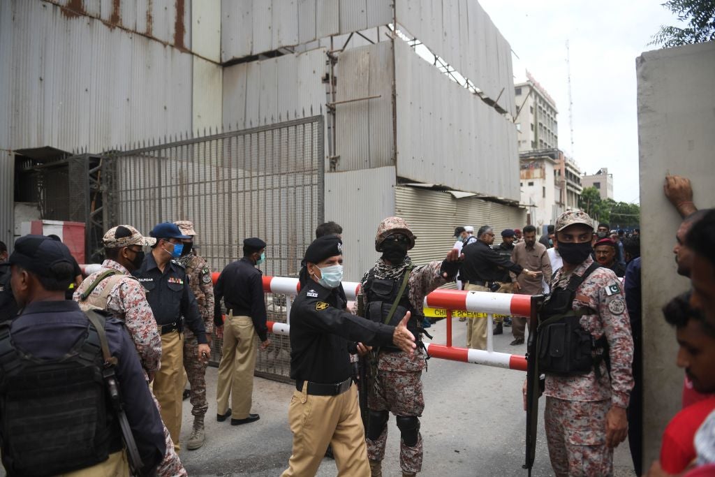 Security personnel stand guard outside the Pakistan Stock Exchange building following attack by gunmen