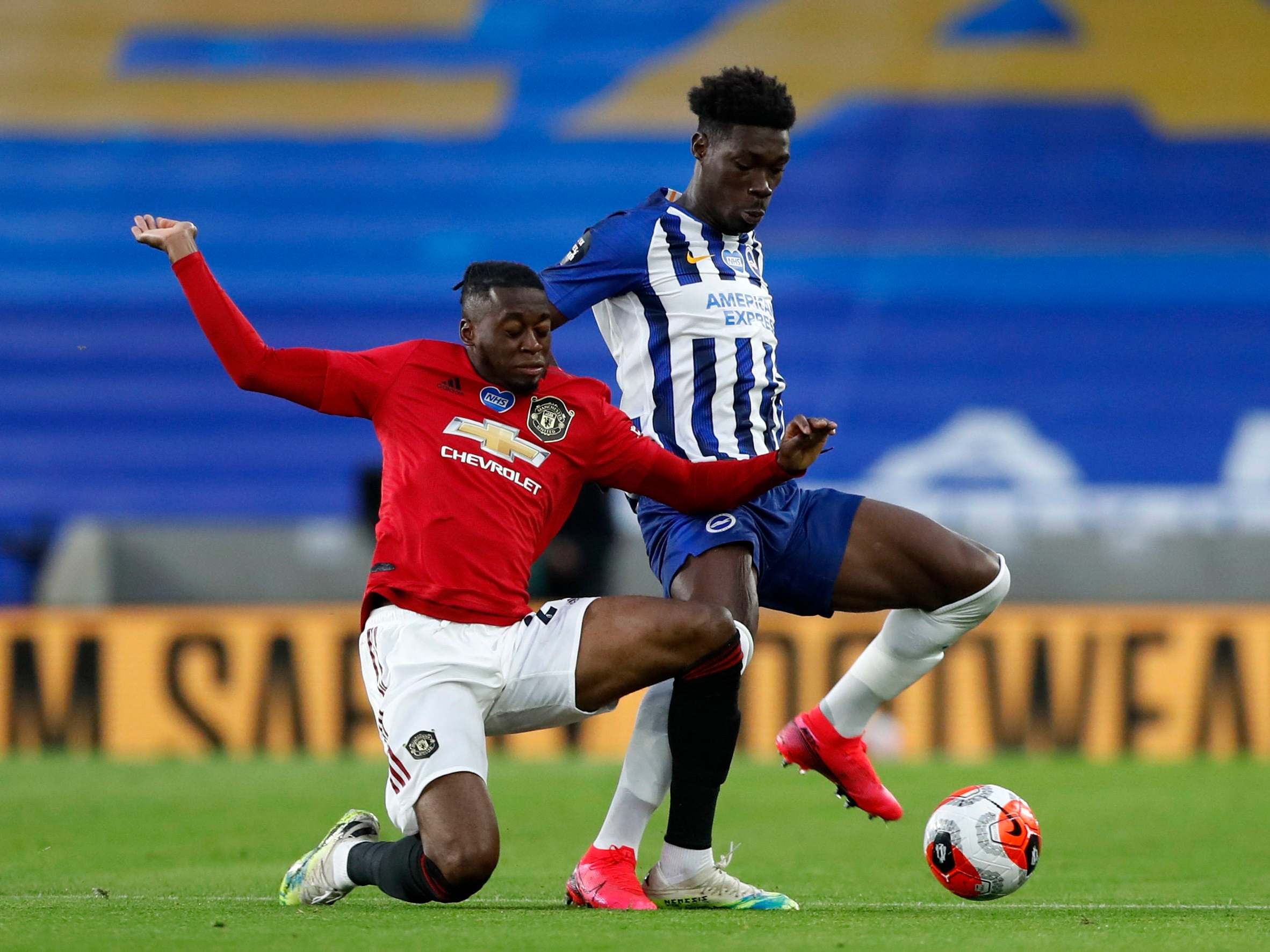 Aaron Wan-Bissaka and Yves Bissouma battle for the ball