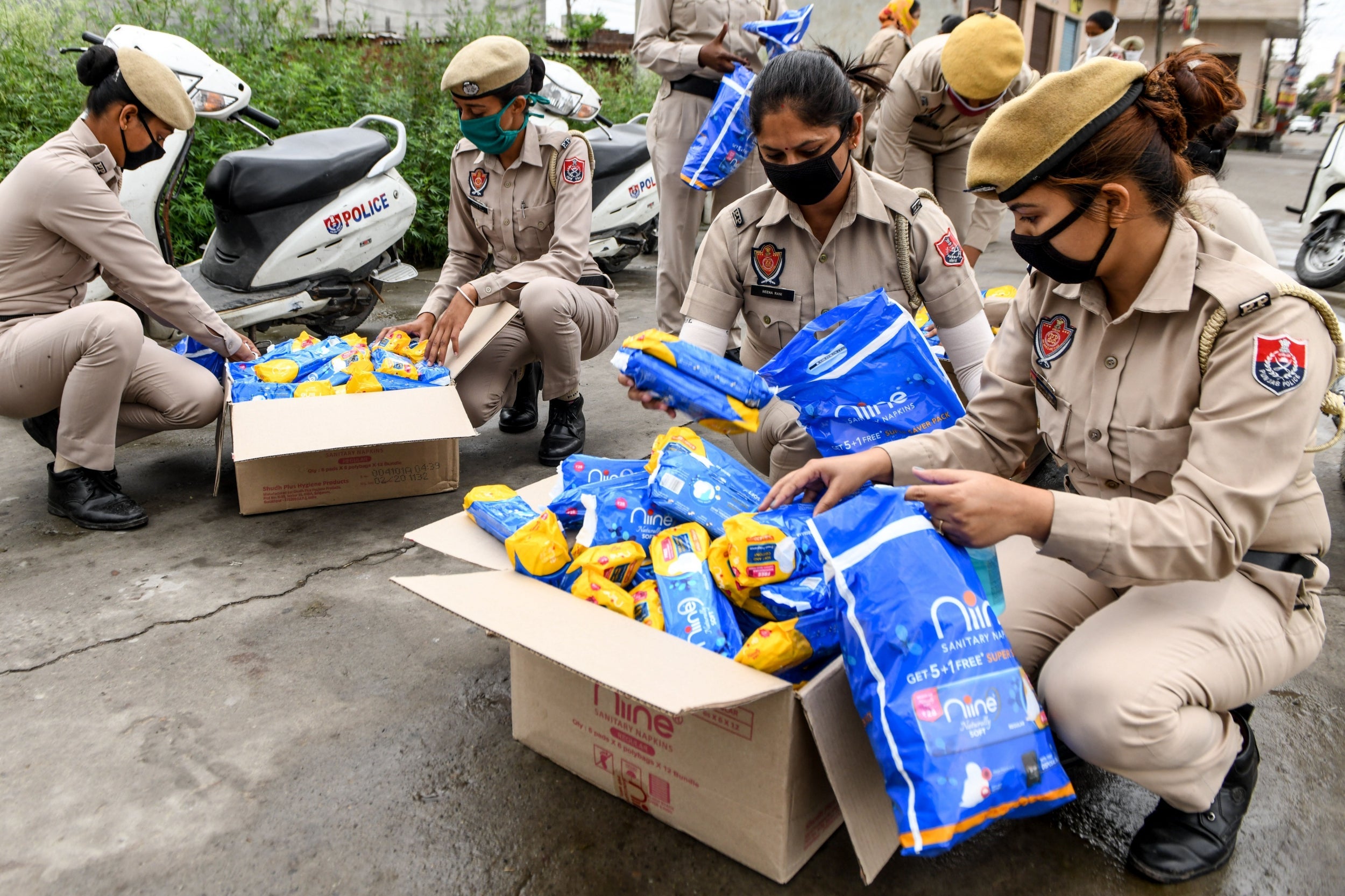 Punjab police personnel pack sanitary pads in boxes before distributing them to residents (AFP /Getty)