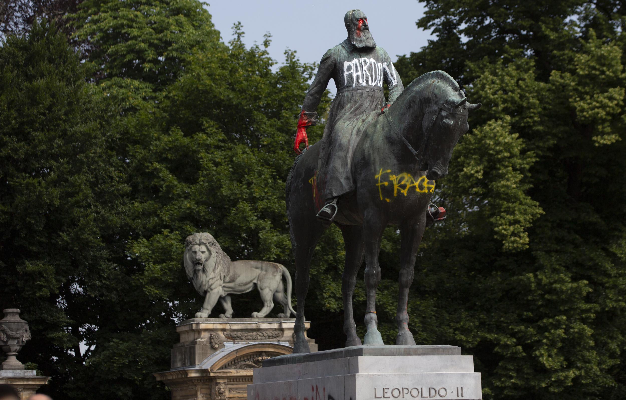 A statue of Belgium’s King Leopold II is smeared with red paint and graffiti in Brussels