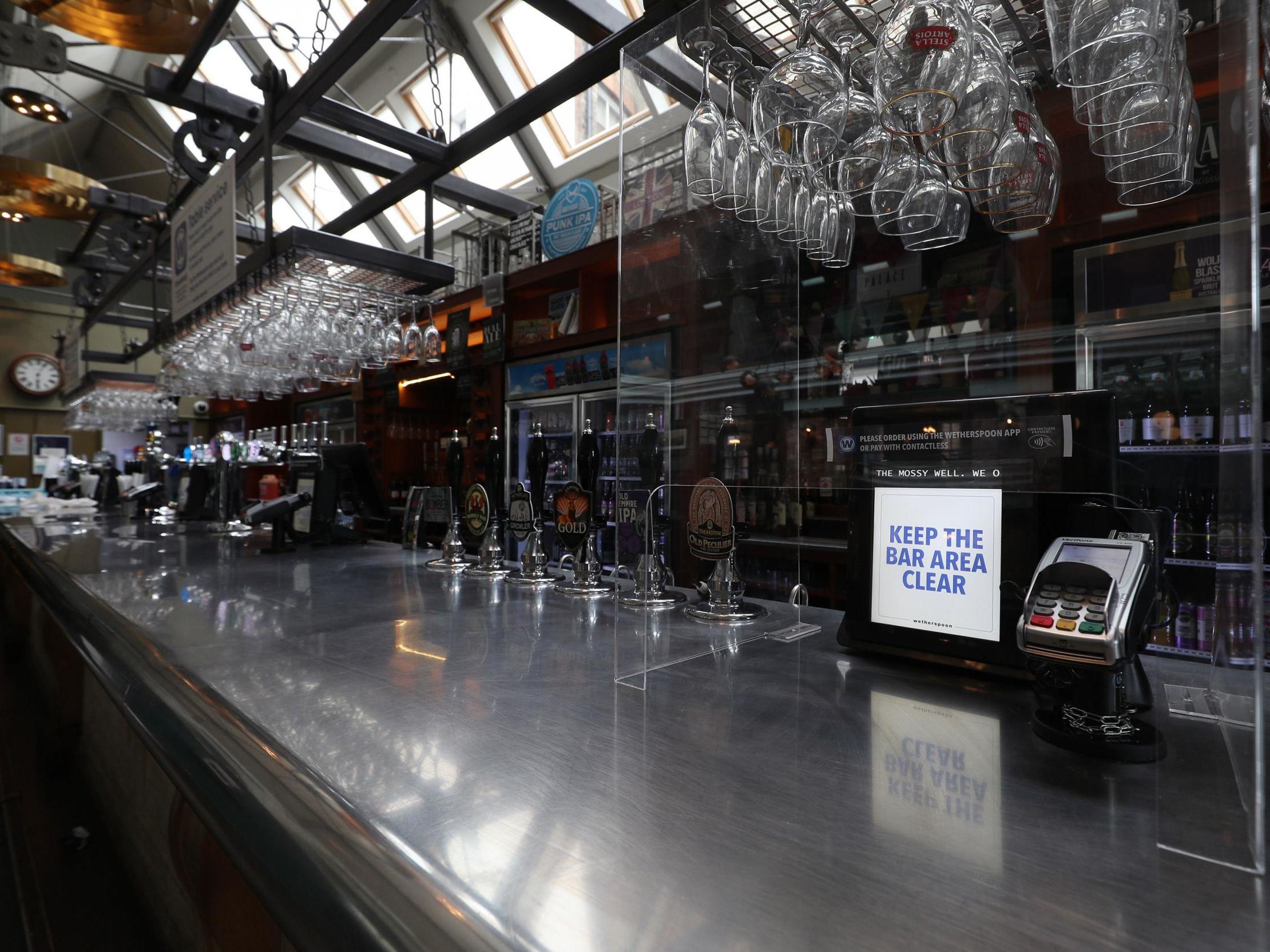 A protective shield for customers surrounds the card payment machine at the bar of a Wetherspoons pub in Muswell Hill, London, ahead of pubs reopening on 4 July.