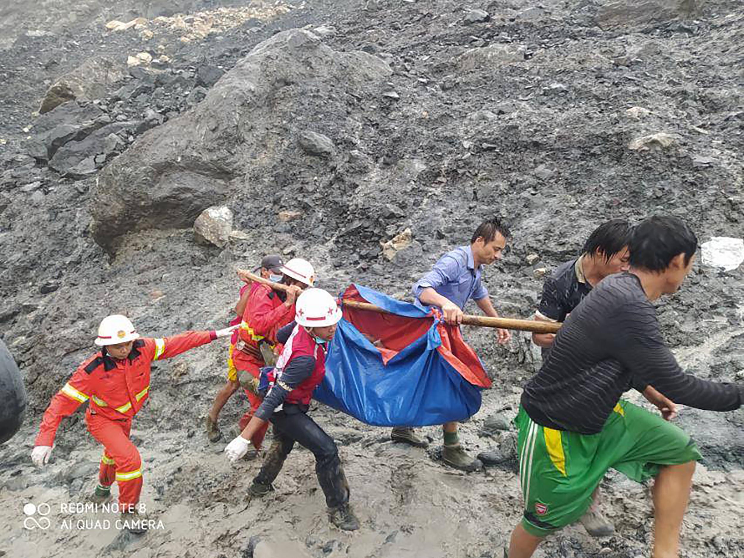 Rescuers carry a recovered body of a victim