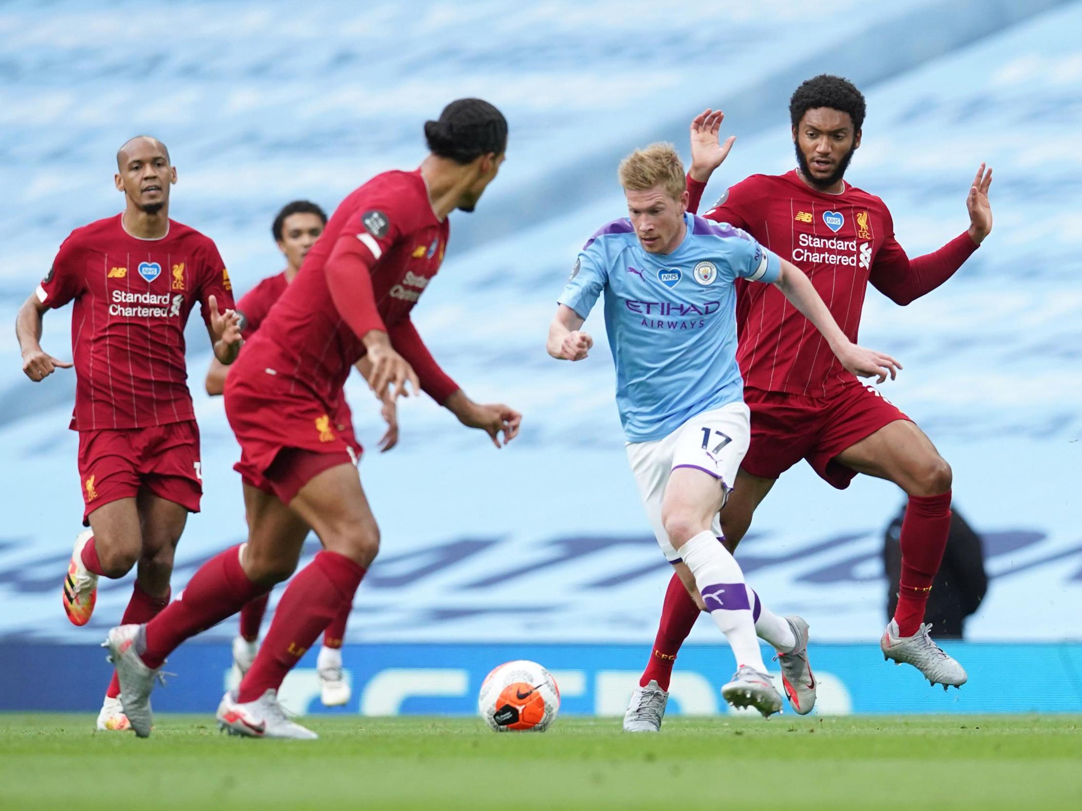 Kevin De Bruyne is challenged by Joe Gomez