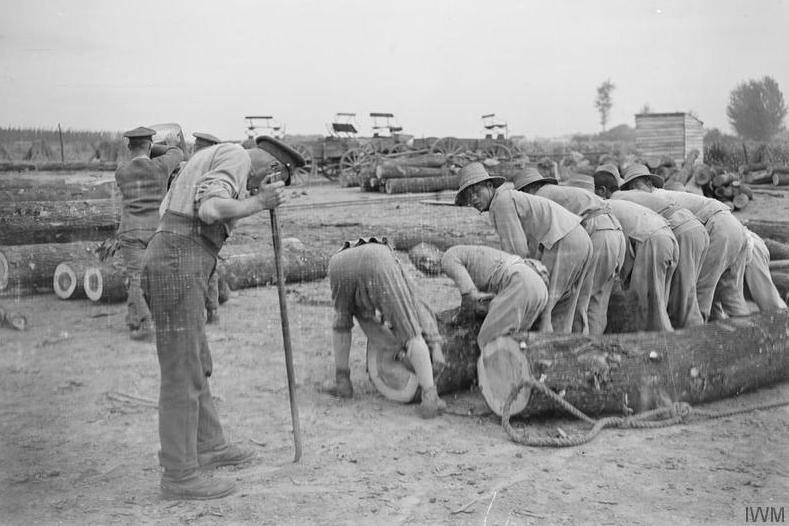 Members of the Chinese Labour Corps and British soldiers working at a timber yard in Caëstre, a commune in northern France, in July 1917