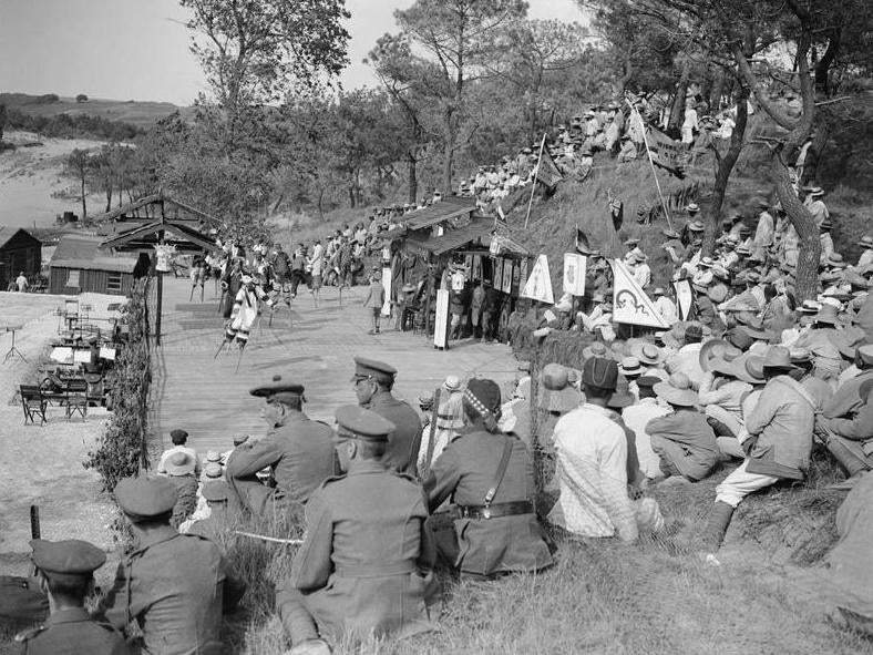 Chinese performers entertain Labour Corps and British soldiers at an open-air theatre in Étaples in June 1918. The two audiences are segregated by a wire fence