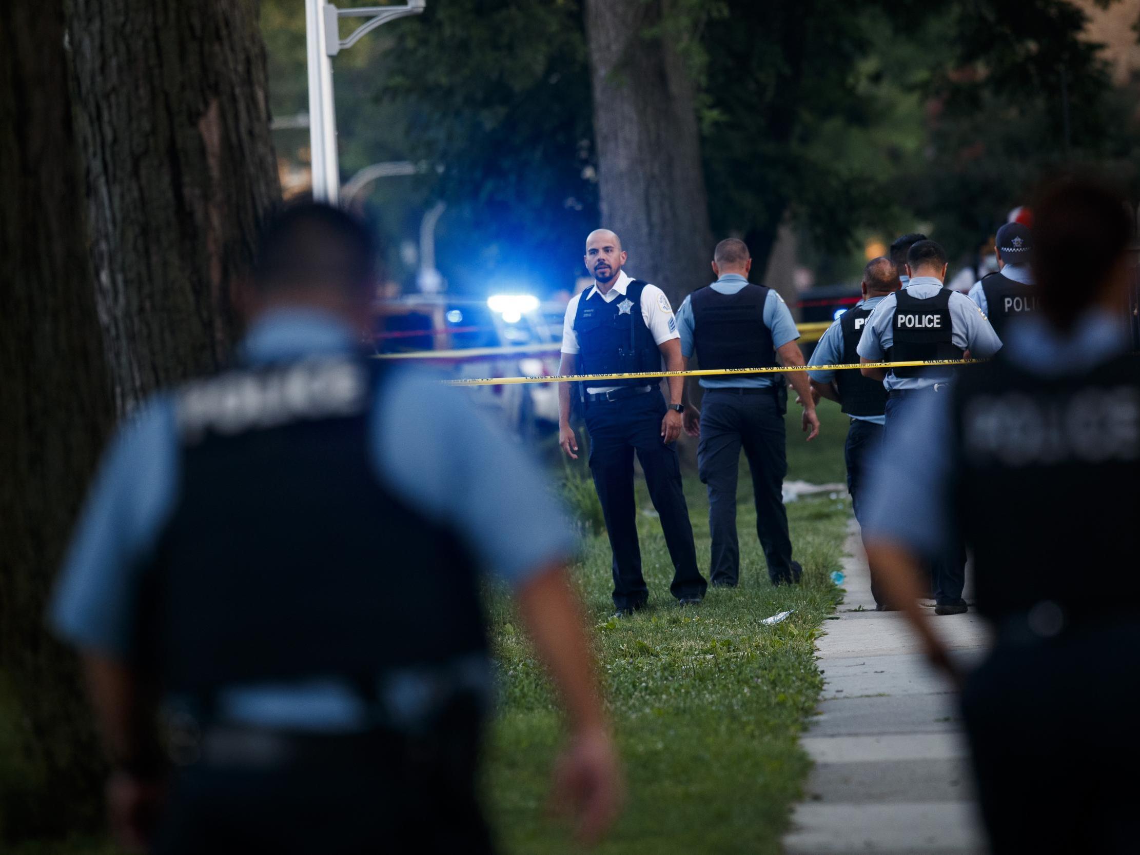 An officer investigates the scene of a deadly shooting where a 7-year-old girl and a man was fatally shot in Chicago on Sunday