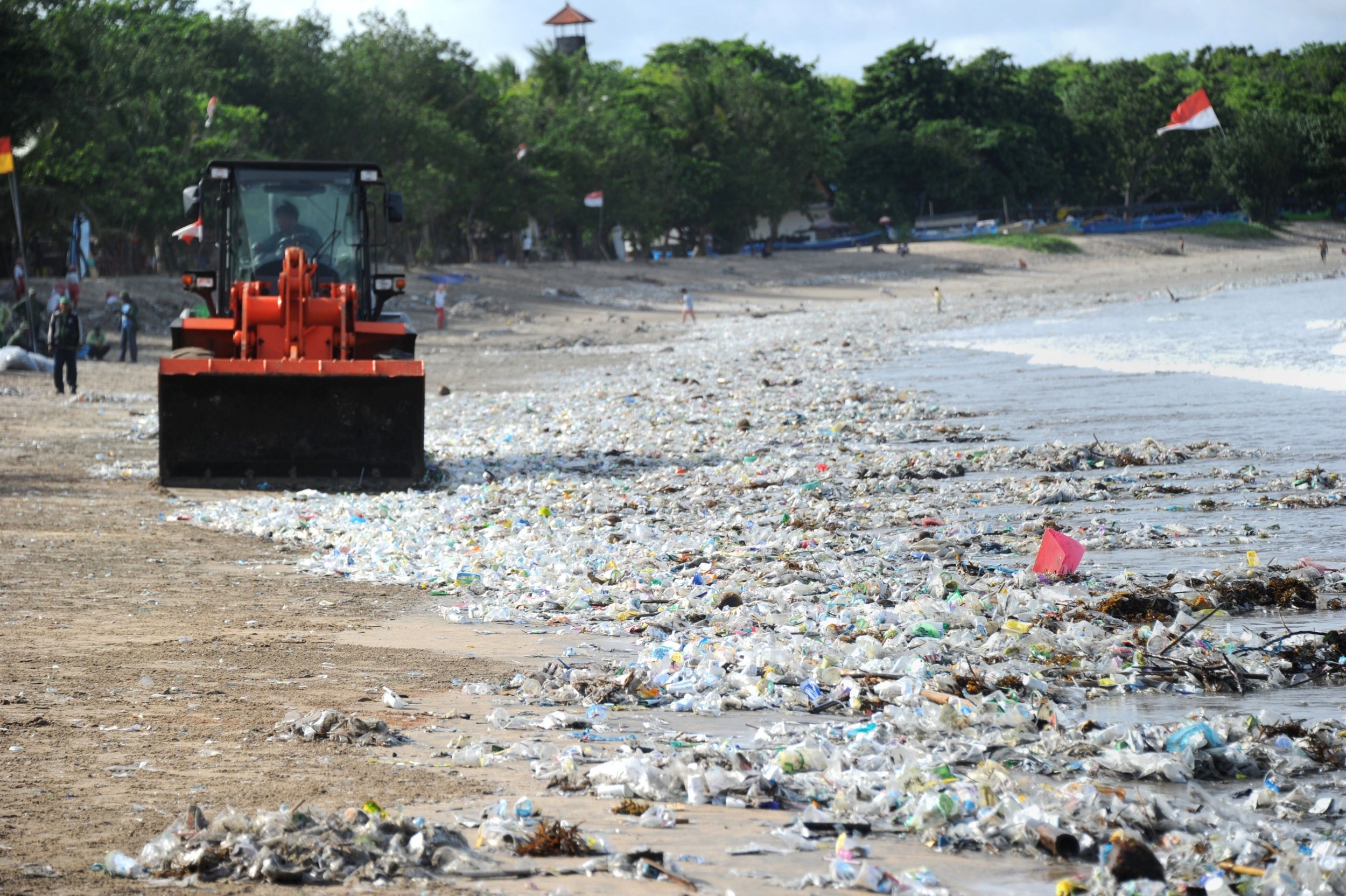 Rubbish collectors clear plastic on Kuta beach, Bali