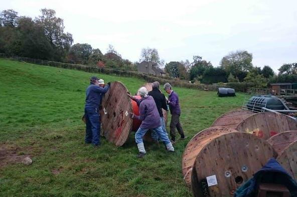 Keep rolling: locals move a reel of plastic across a field