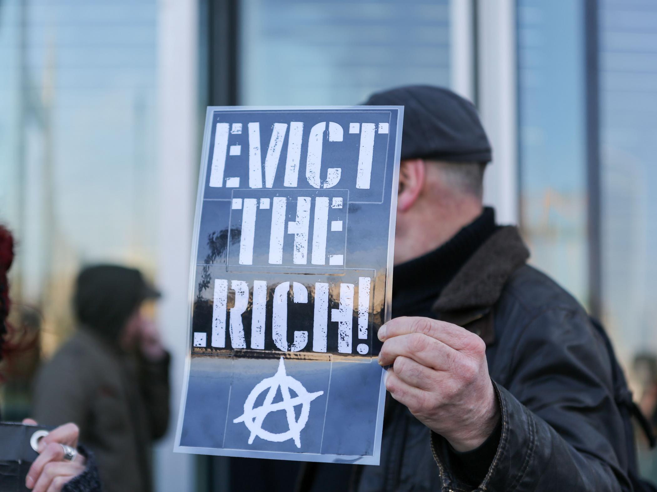 An anarchist holds aloft a placard at an anti-gentrification protest in London in 2018