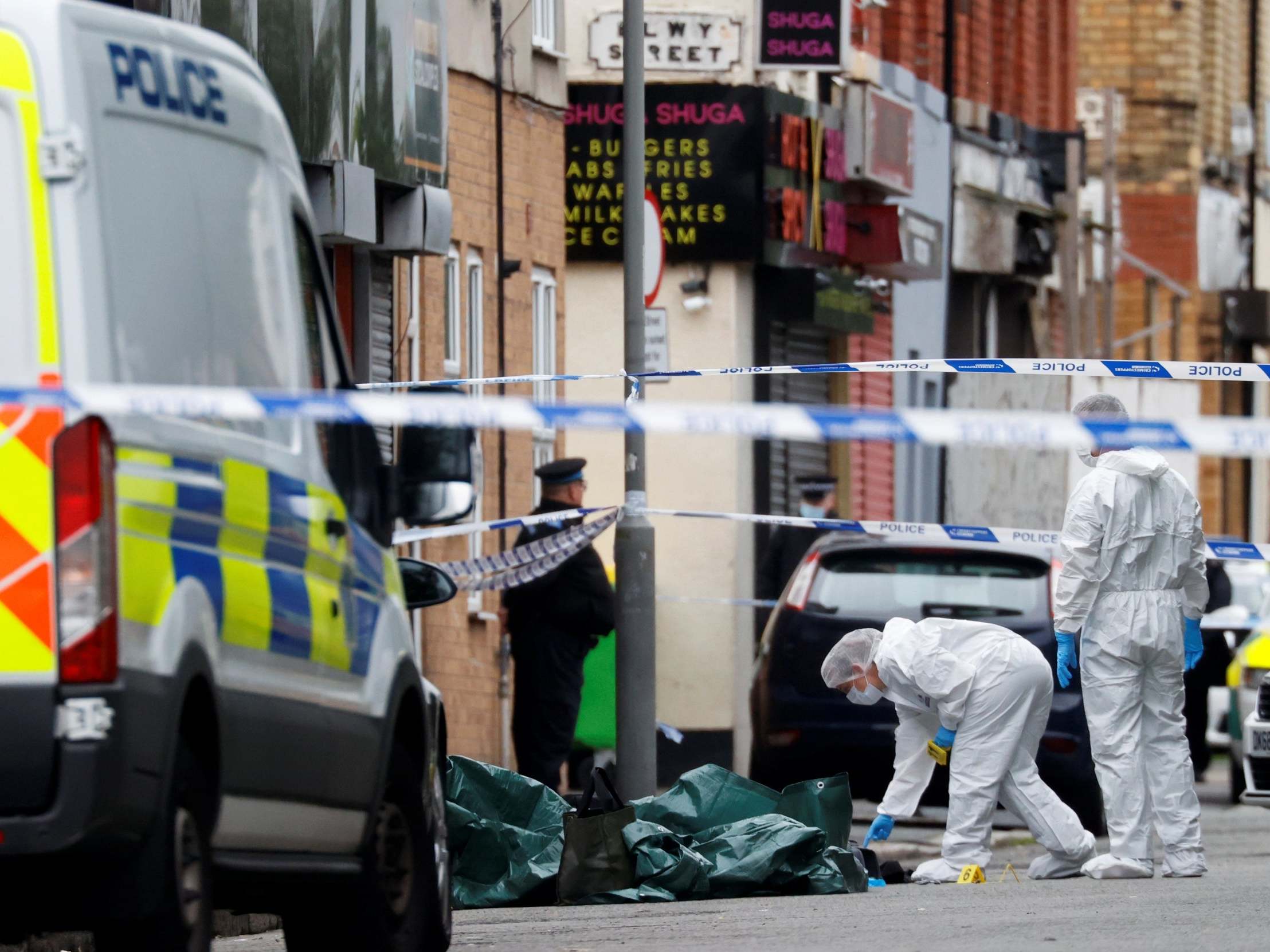 Police officers examine the scene in Toxteth, Liverpool, where a woman was shot by police on 9 July 2020.