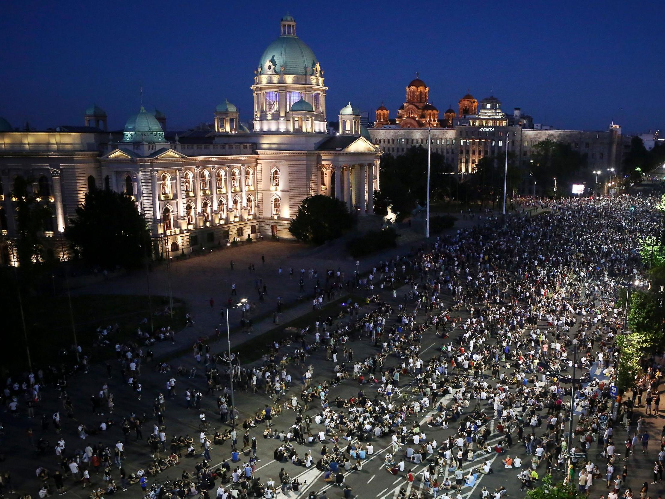 Demonstrators peacefully sit on the street in front of the parliament during a protest in Belgrade