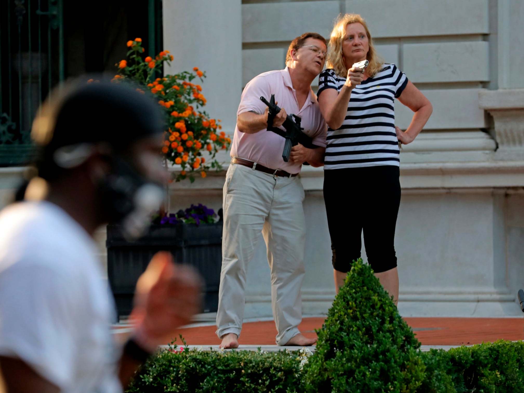 Mark and Patricia McCloskey pointing guns at Black Lives Matters protesters in St Louis in June