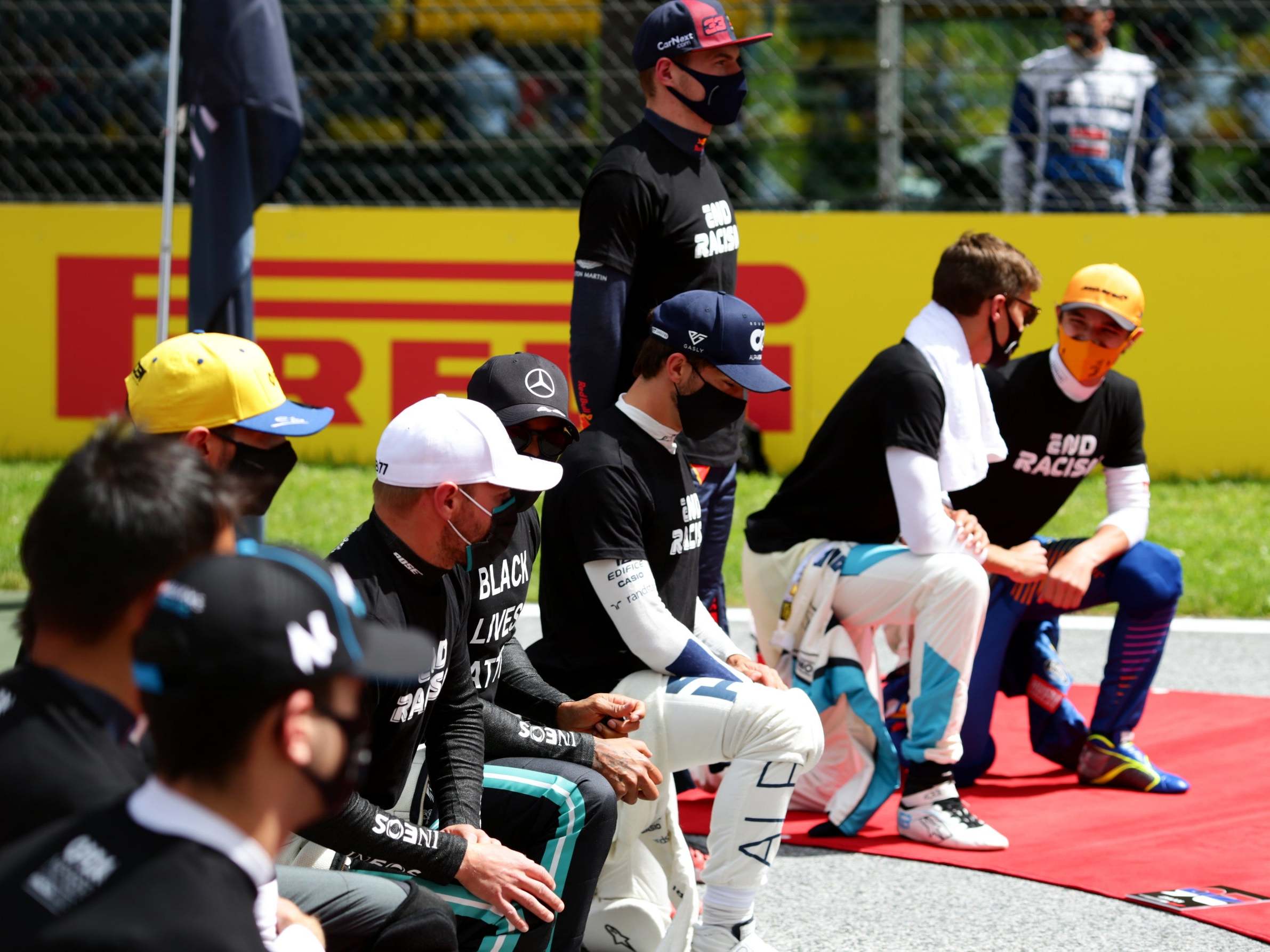 Max Verstappen stands while other F1 drivers take a knee ahead of the Styrian Grand Prix