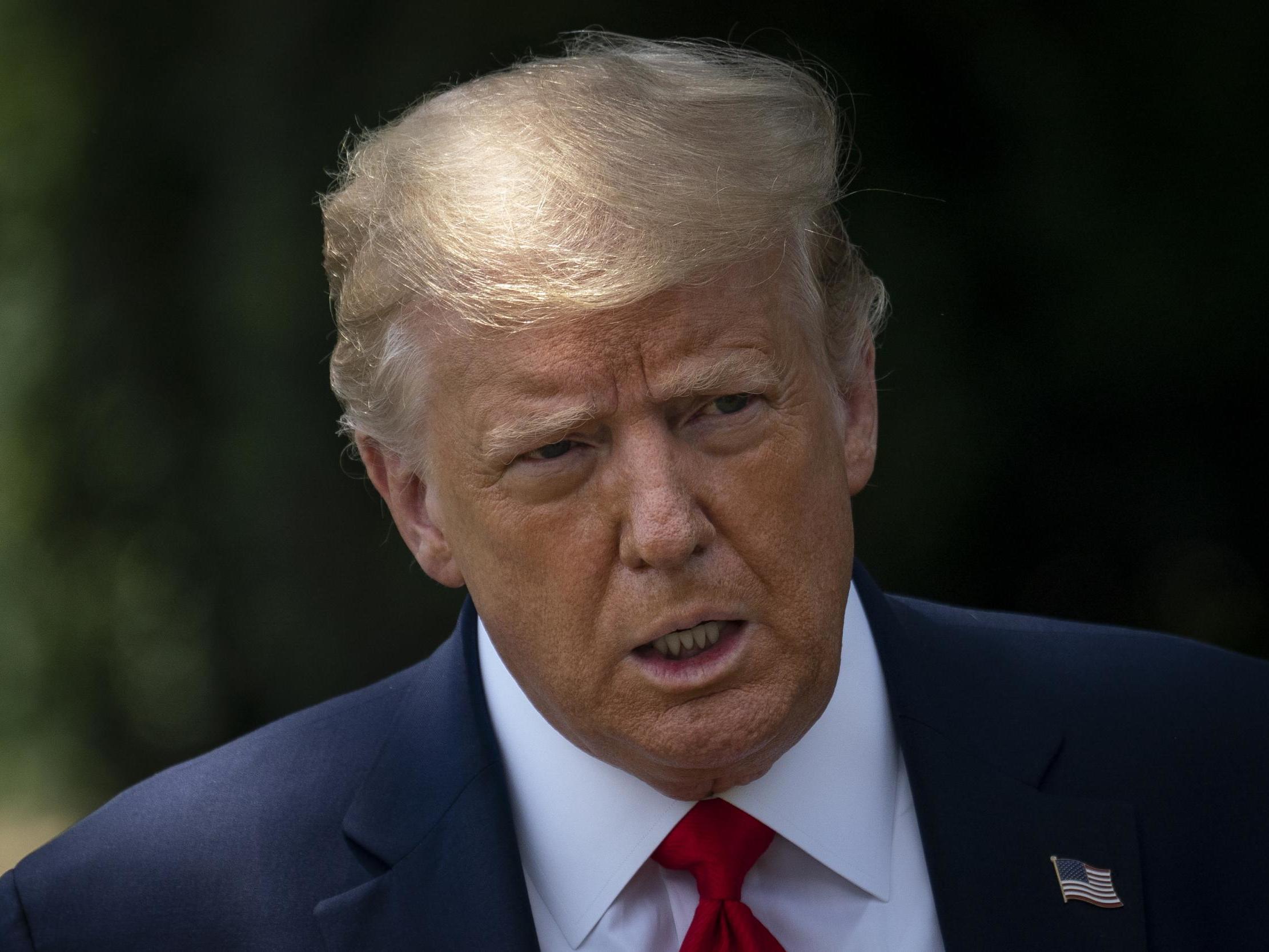 President Donald Trump speaks to reporters on the South Lawn of the White House before boarding Marine One on 15 July