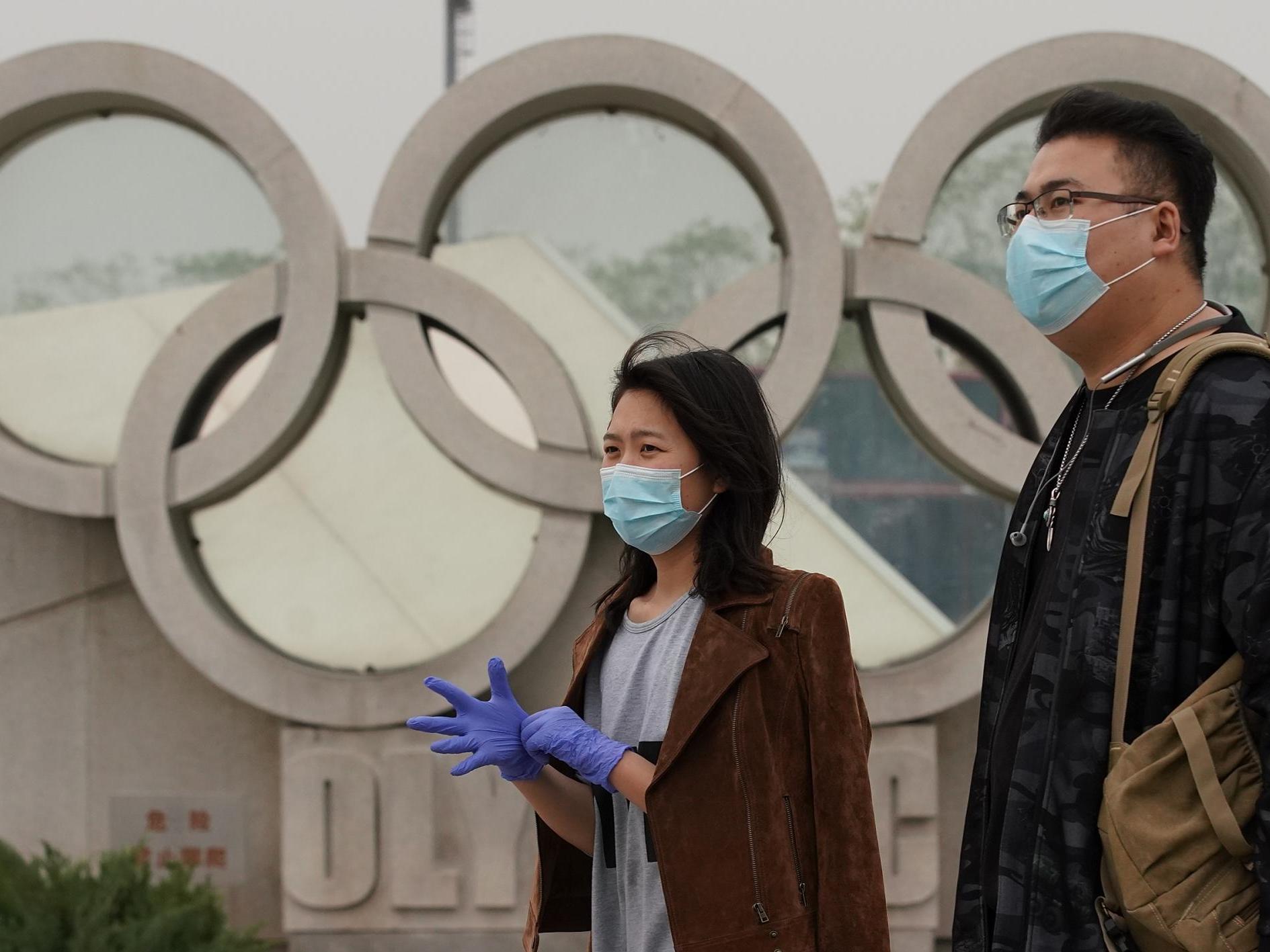 A couple walks past the Olympic Park in Beijing, China