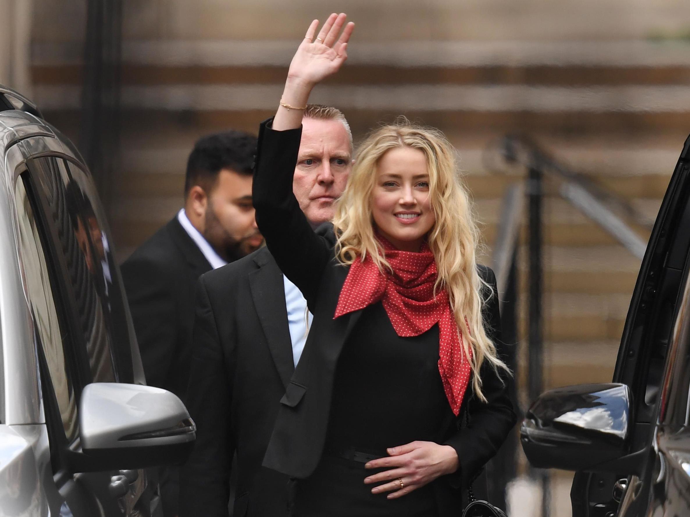 Amber Heard waves as she leaves the High Court in London (AFP/Getty)