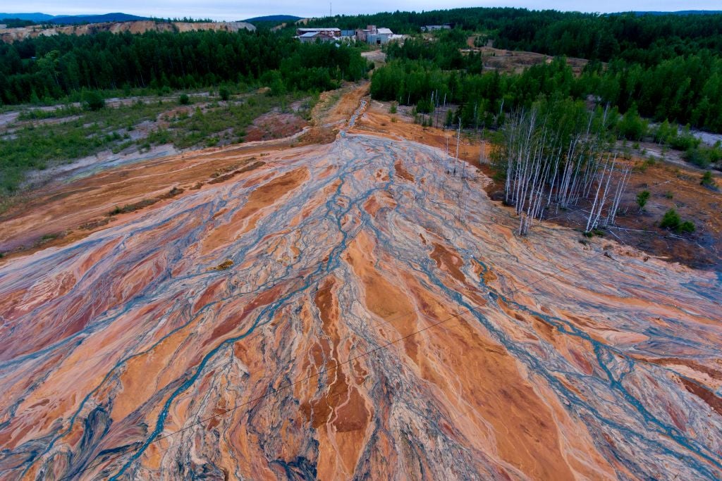 Orange-coloured rivers fan out over forested landscape near village of Lyovikha in the Urals