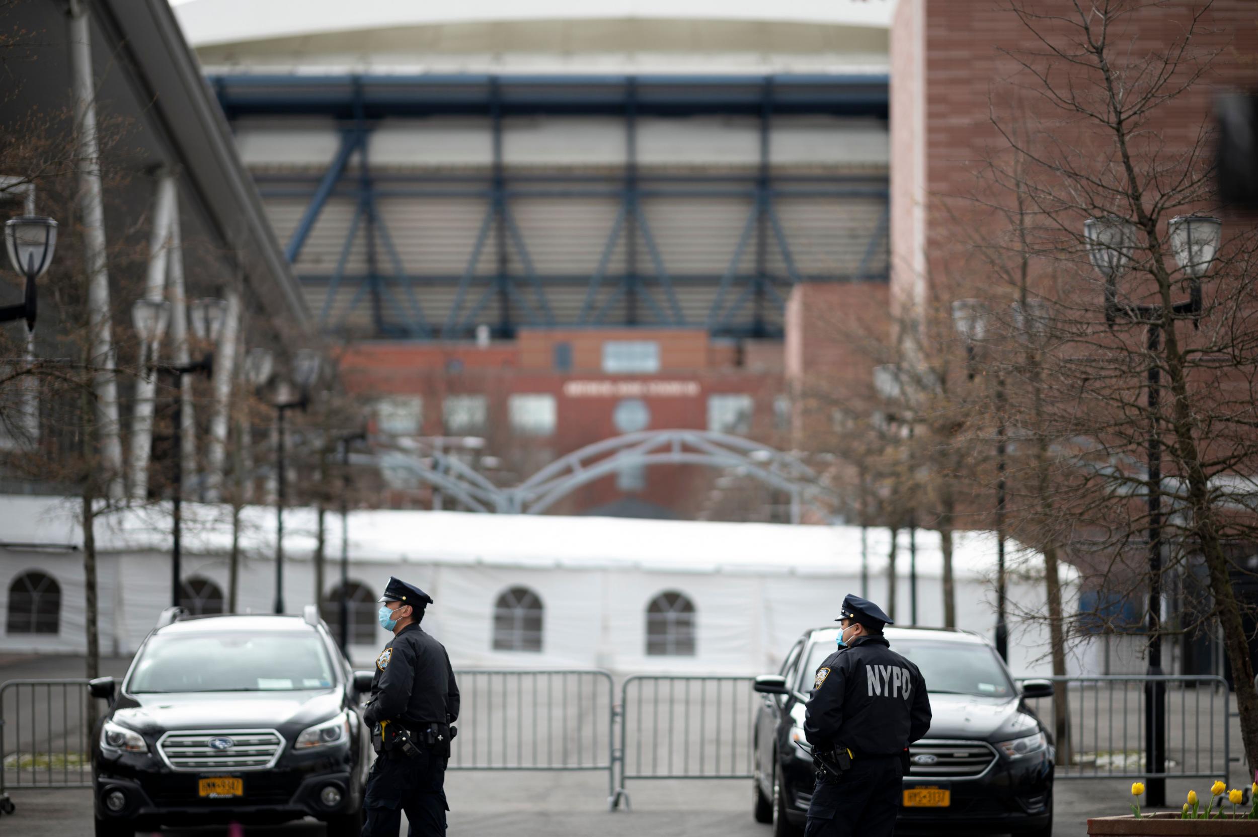 NYPD officers wearing face masks stand outside the temporary Billie Jean King hospital