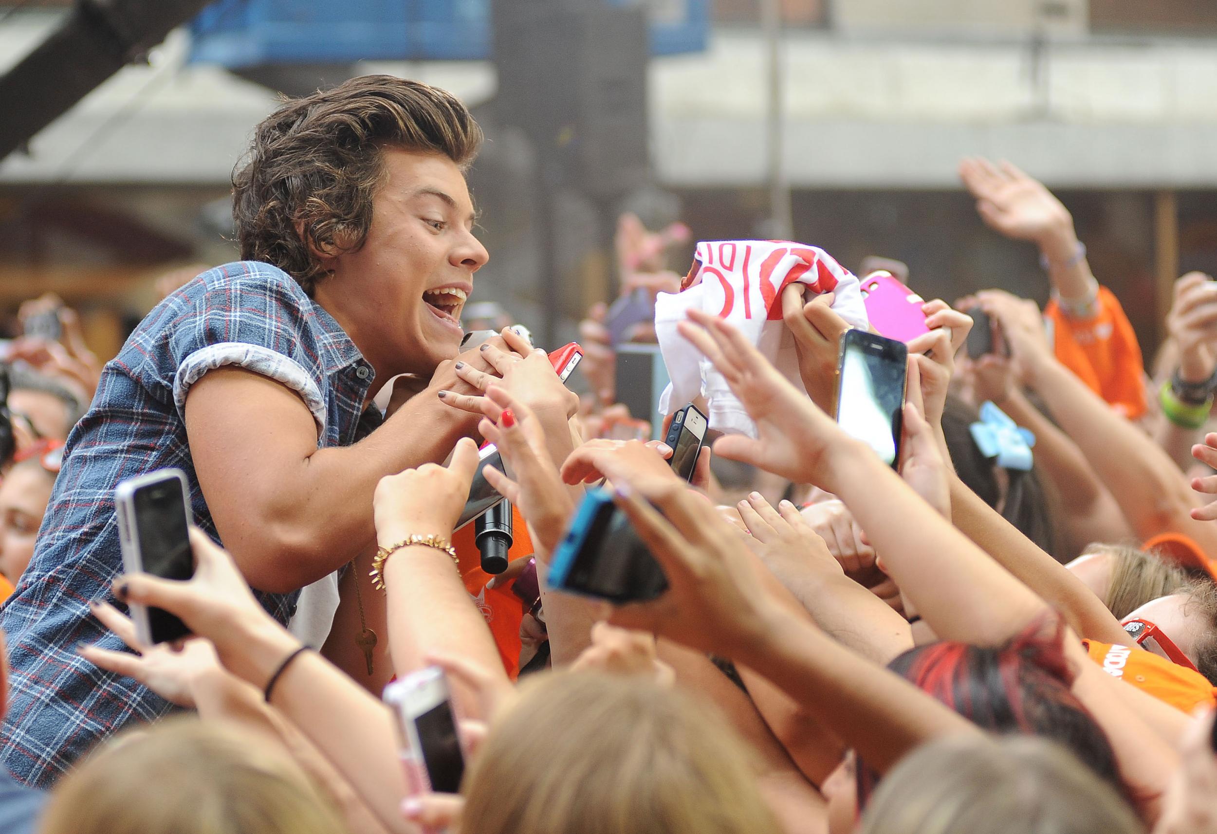 Harry Styles surrounded by a sea of fans at a 2013 live show in the US