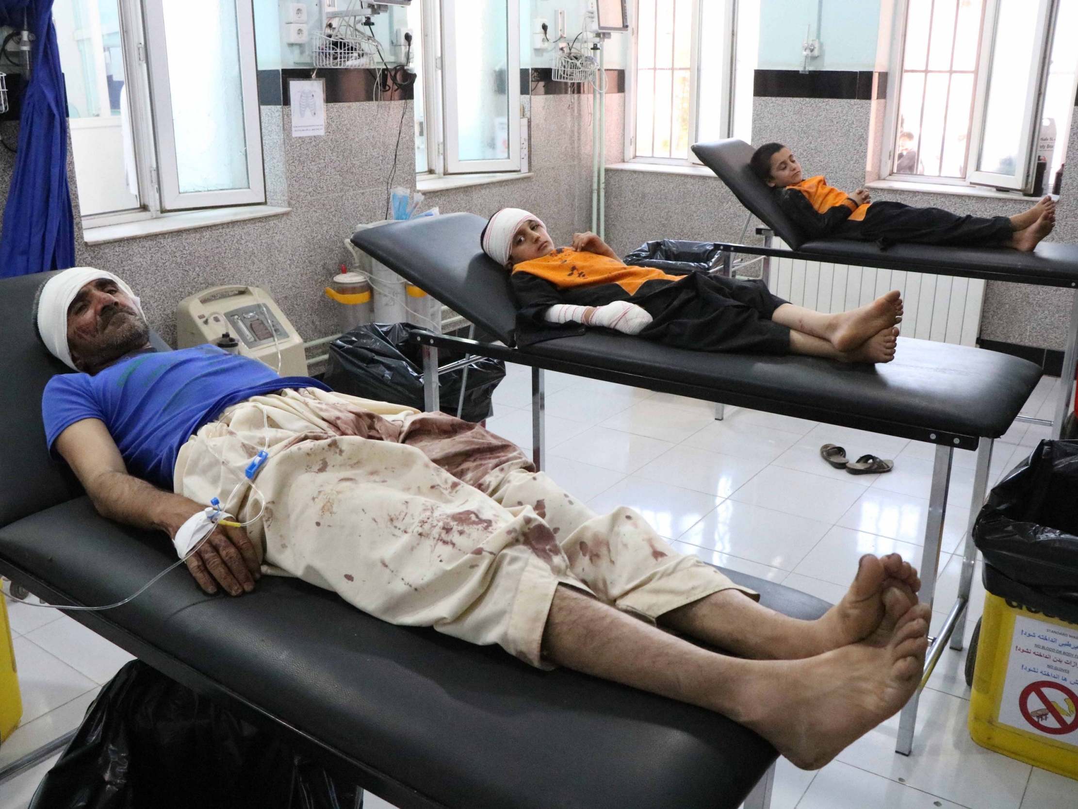 A man and two children injured in the airstrike are treated at a hospital in Herat