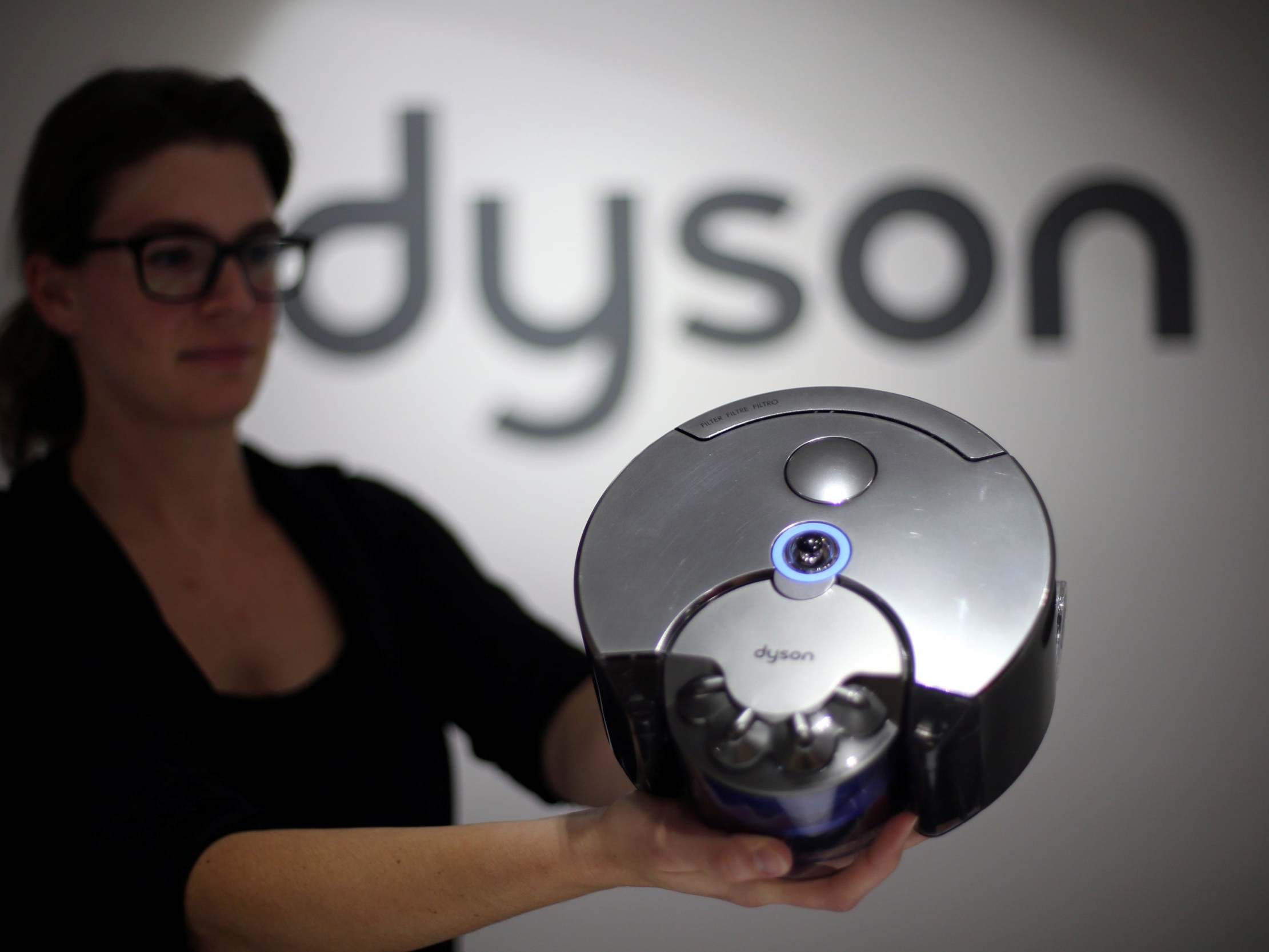 A Dyson employee shows a Dyson 360 Eye robot vacuum cleaner during the IFA Electronics show