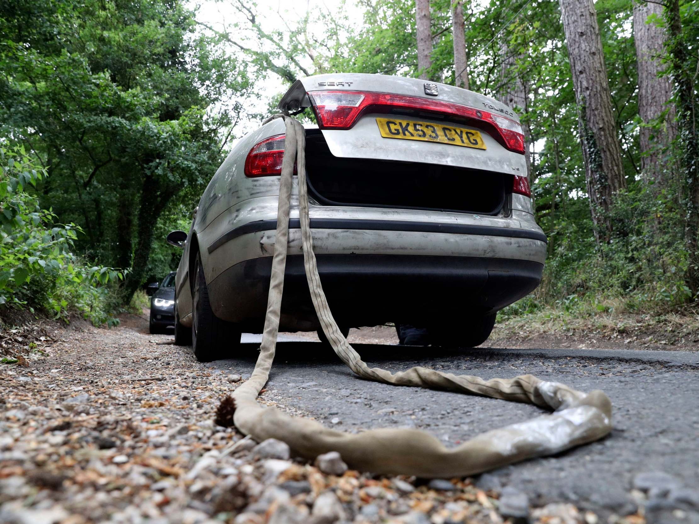 The Seat Toledo with tow rope and the police car in a similar position at the site of the meeting of the vehicles during the Old Bailey jury site visit to the scene in Sulhamstead, Berkshire